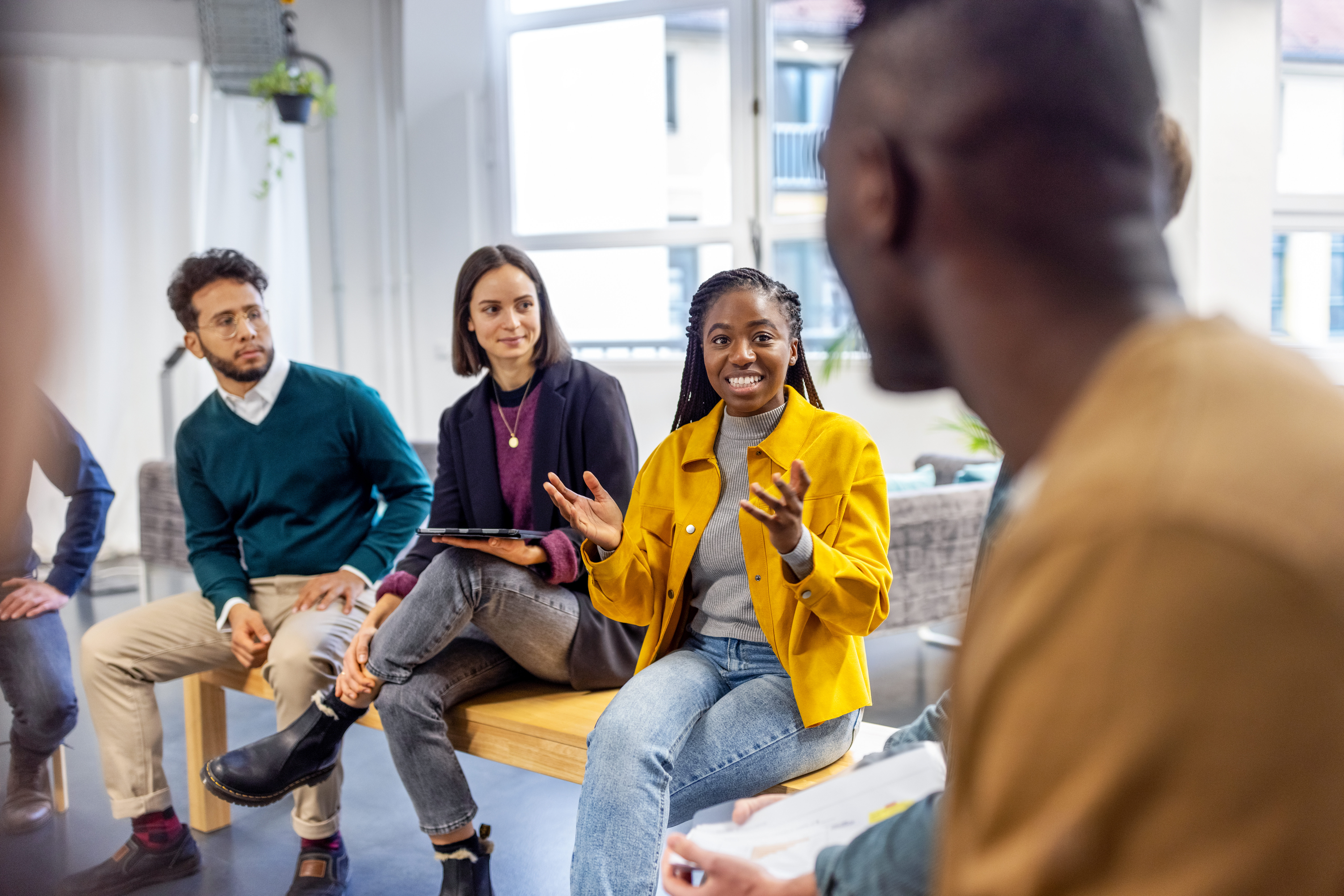 Woman speaking to a group of diverse coworkers at an office