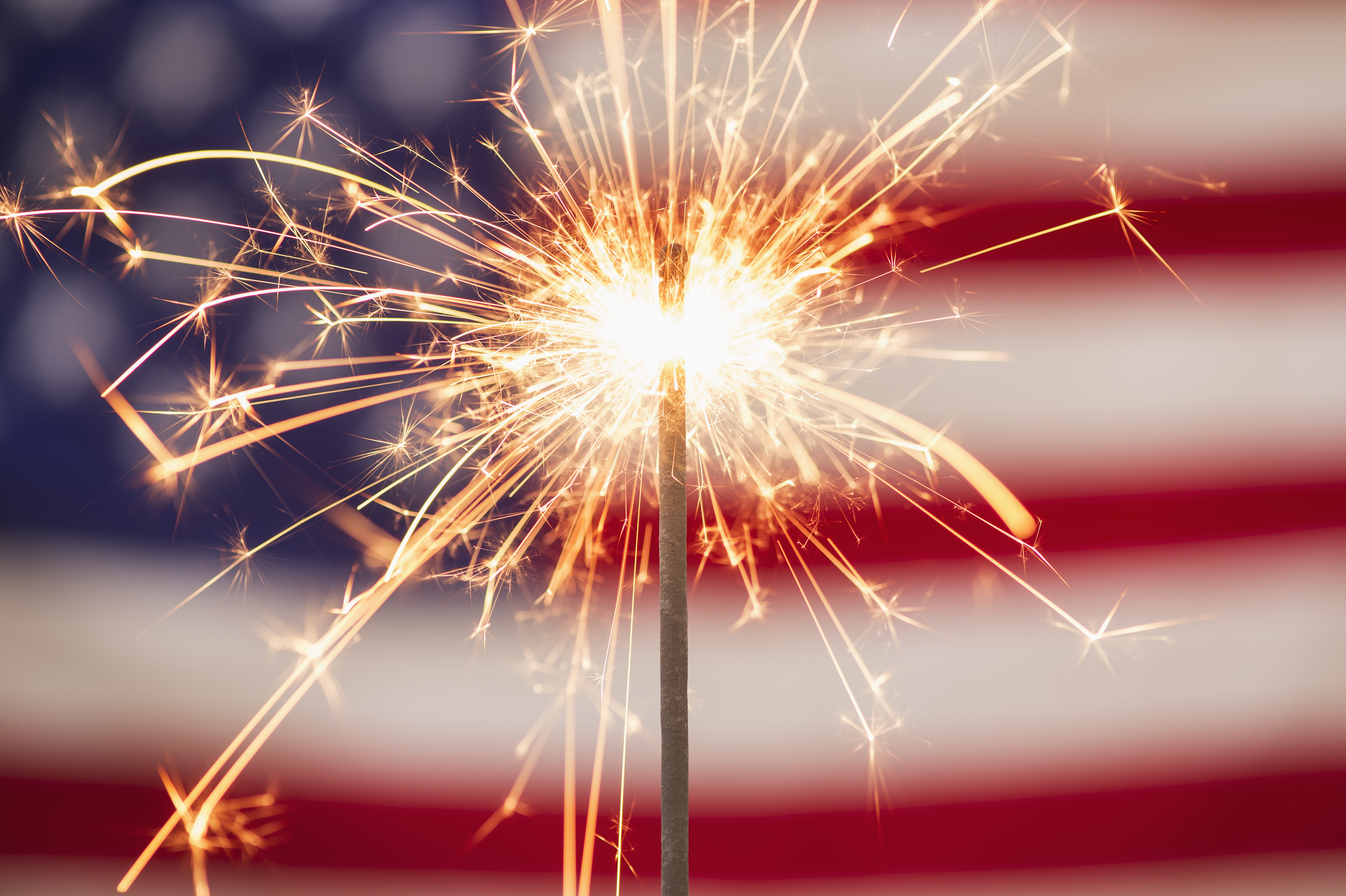 A sparkler in front of the American flag.