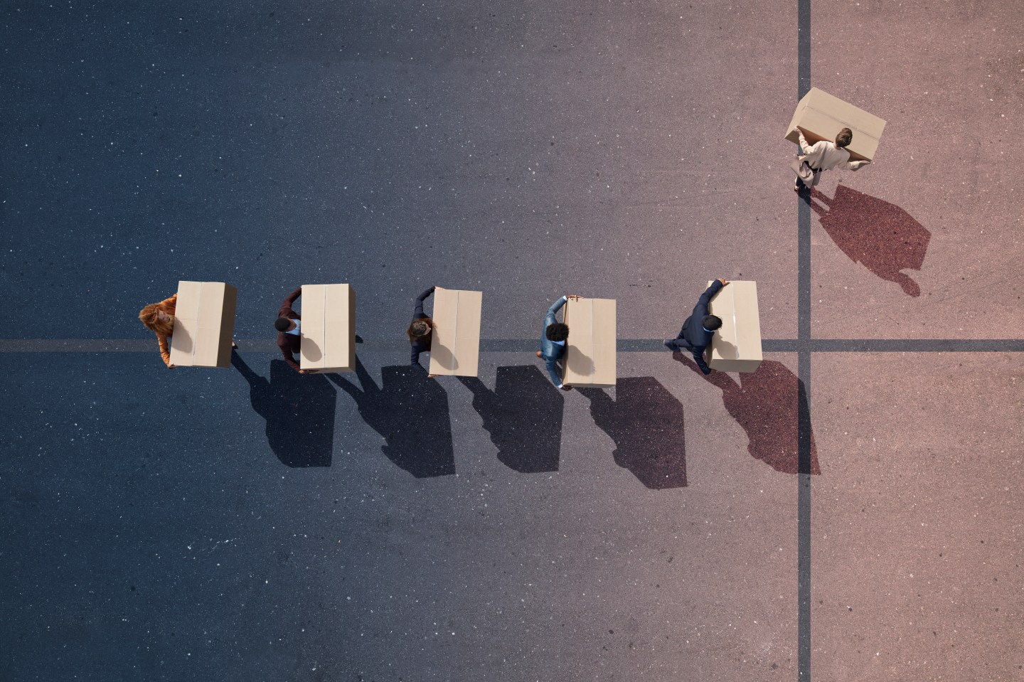 Line of employees in suits carrying boxes