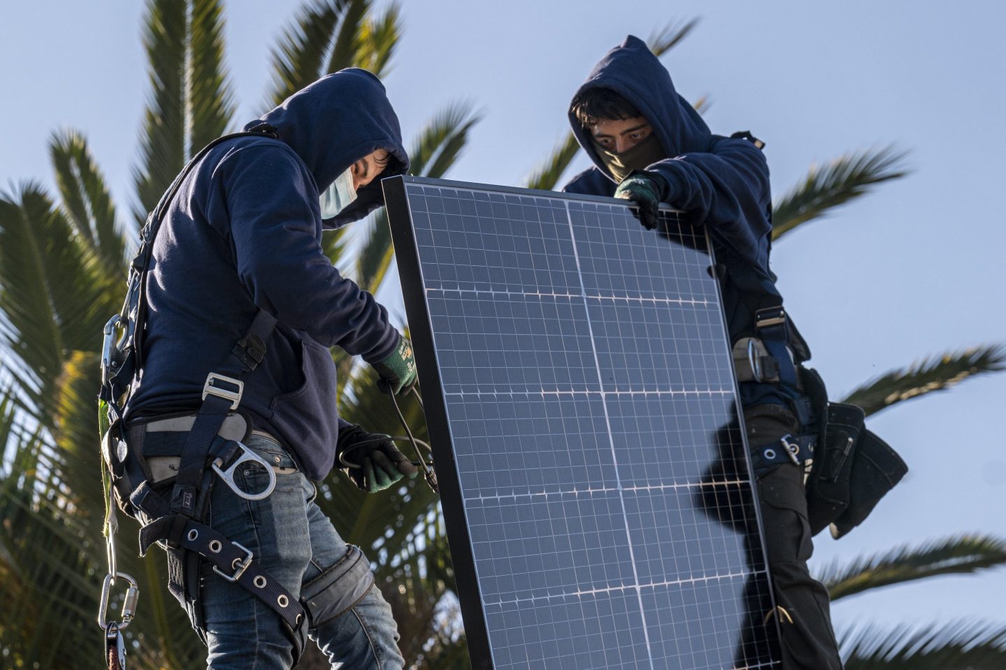 Contractors install solar panels.