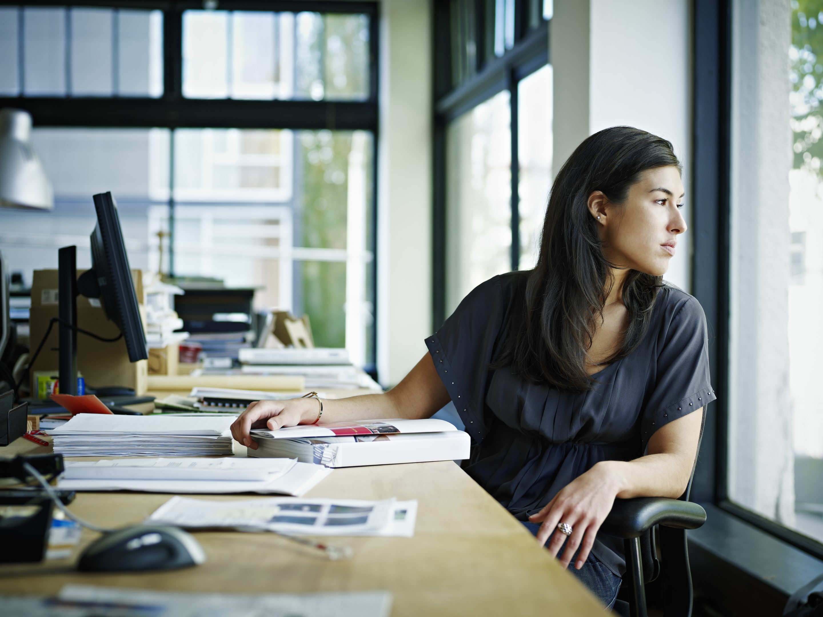 Businesswoman sitting in office looking out