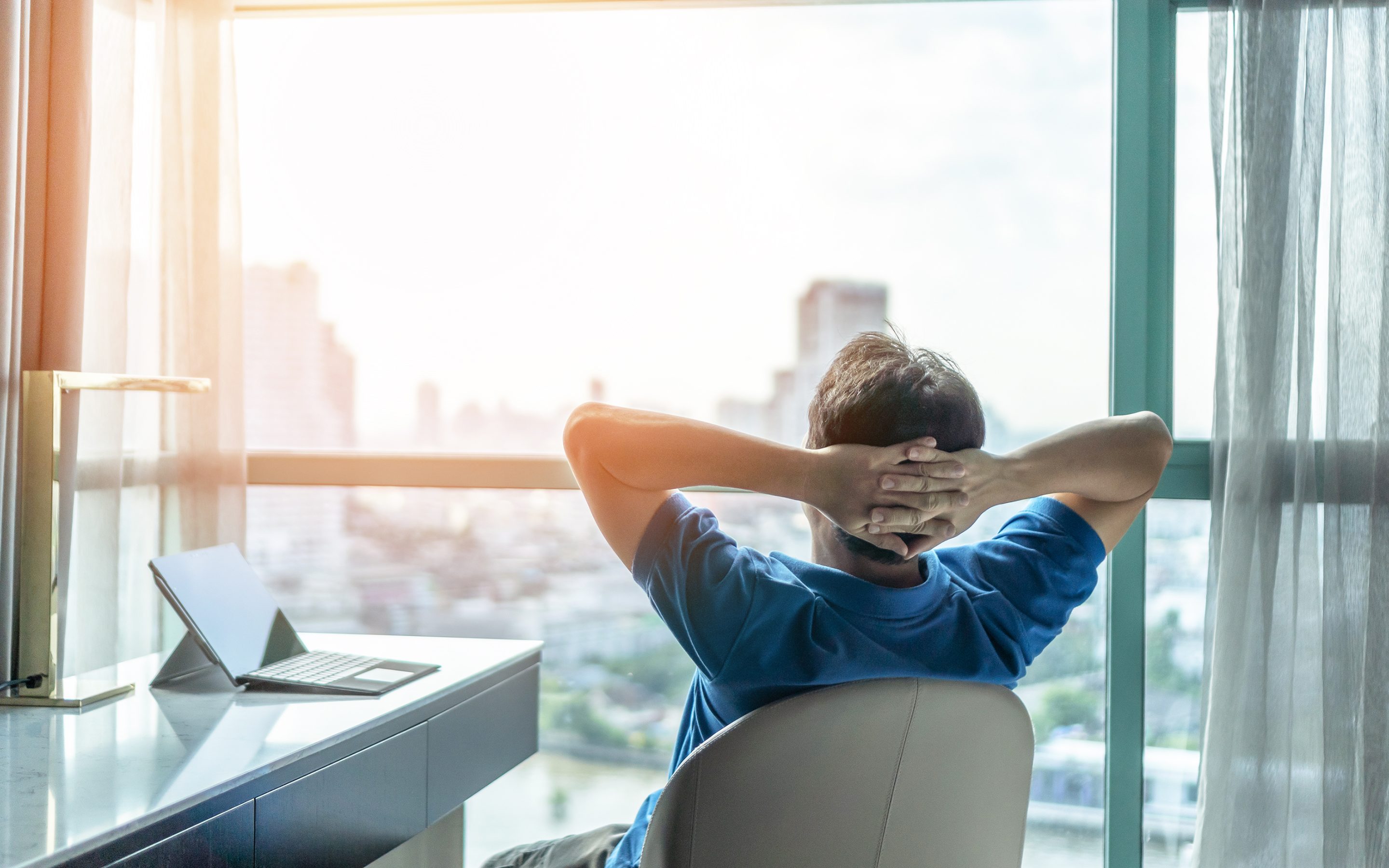 Person leans back in an office chair and daydreams.