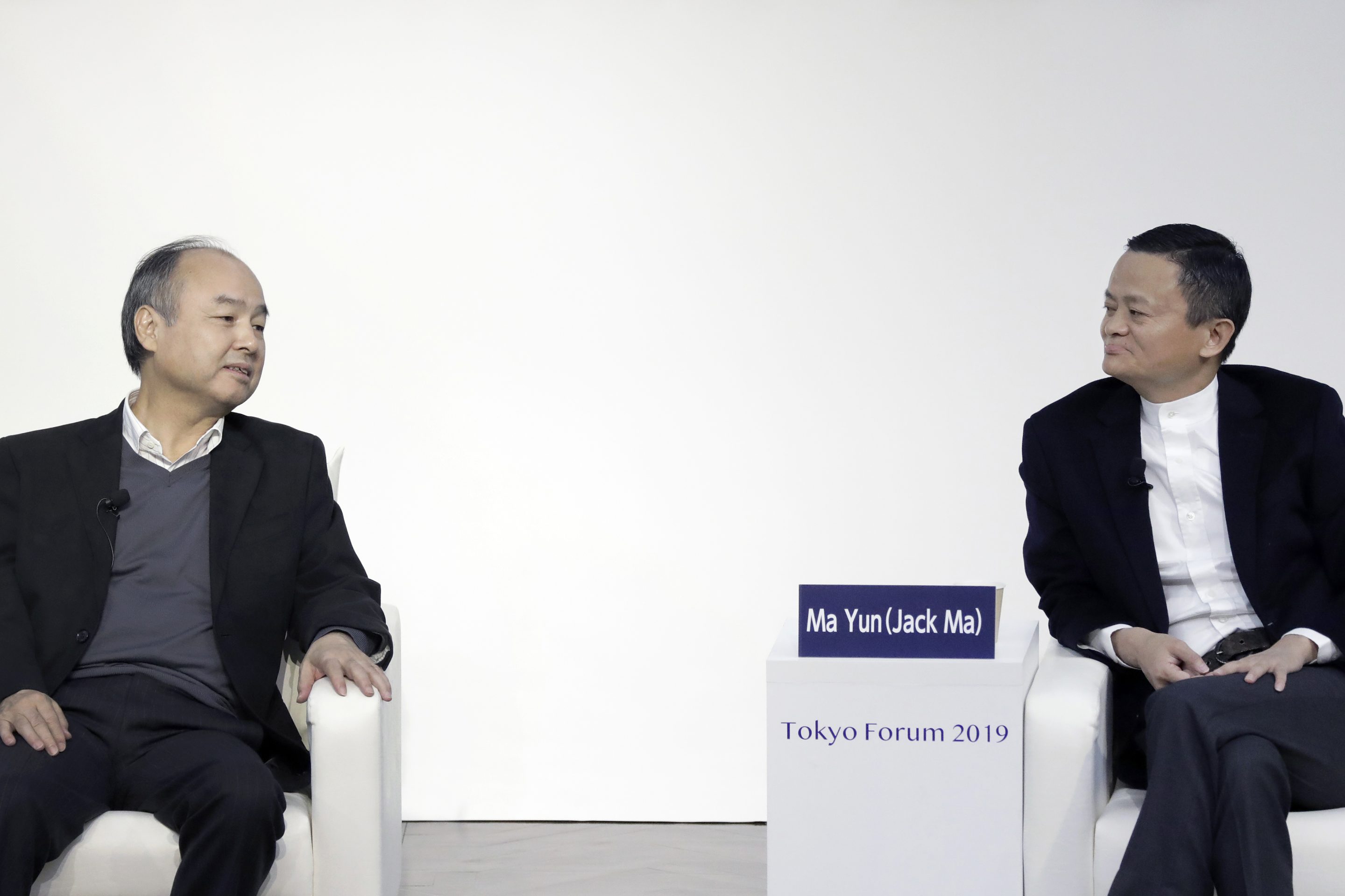 Masayoshi Son, chairman and chief executive officer of SoftBank, left, speaks while Jack Ma, former chairman of Alibaba, listens at Tokyo Forum 2019.