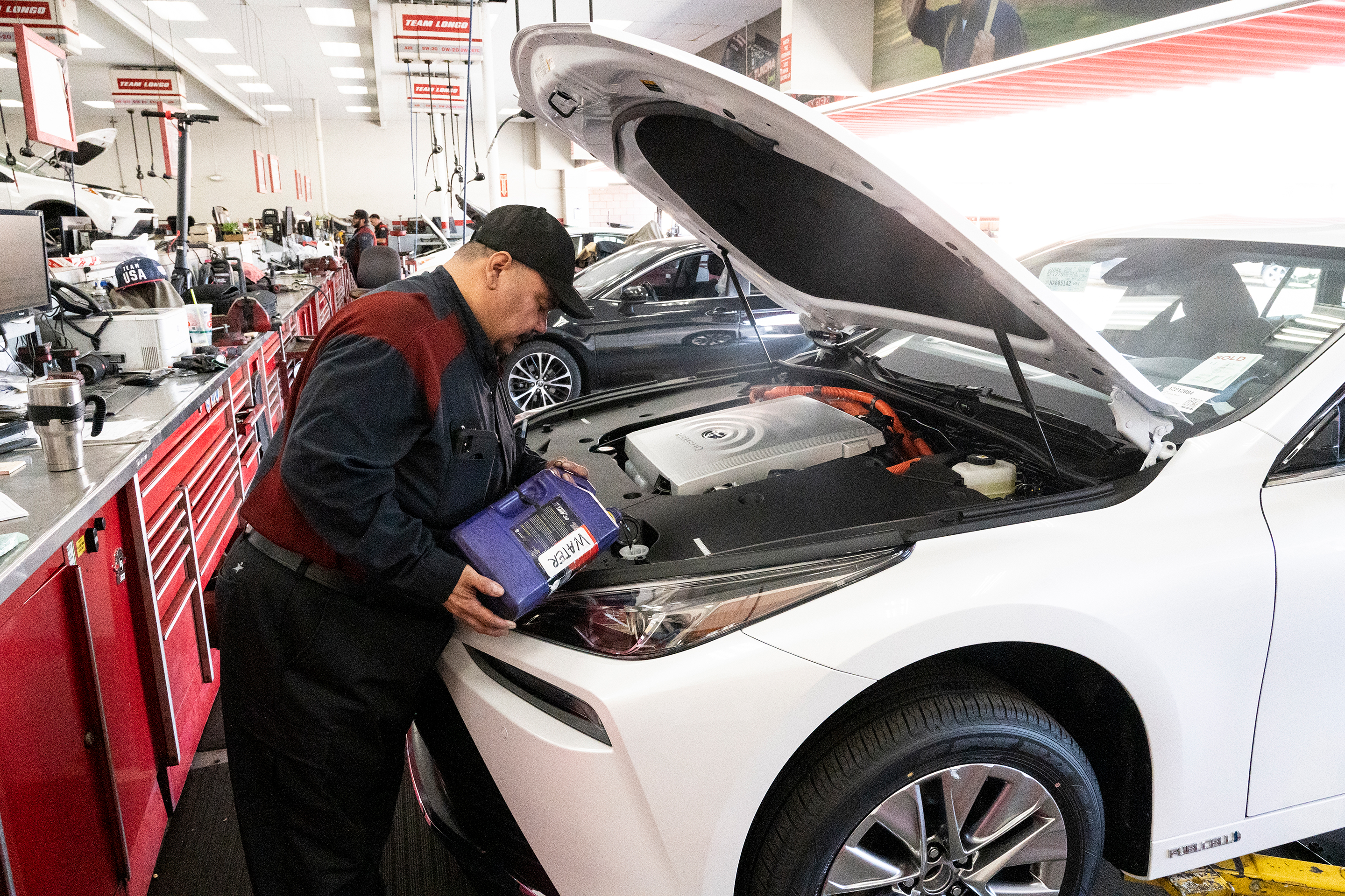 A technician prepares a 2022 Toyota Mirai hydrogen fuel-cell car for a customer.
