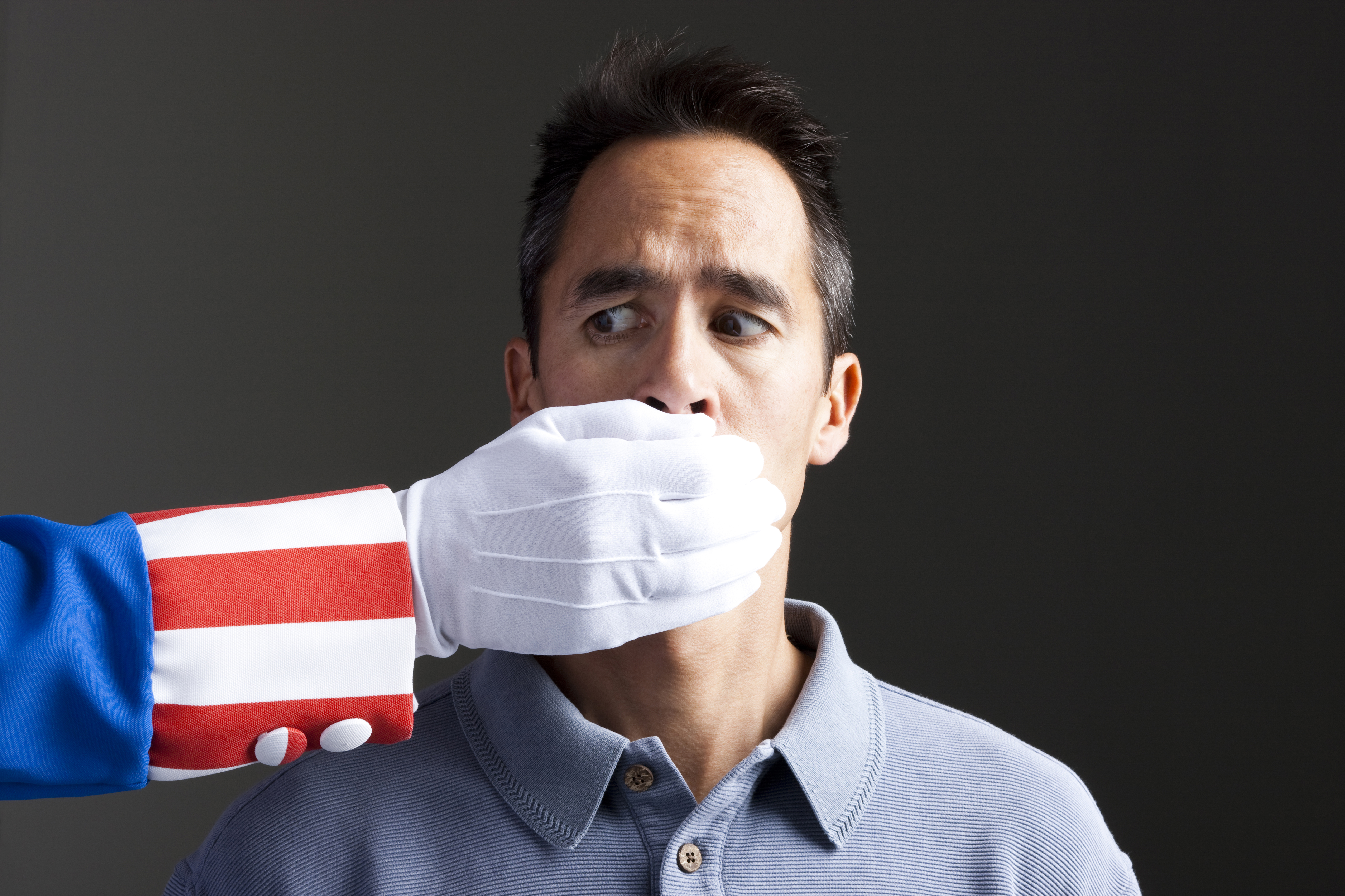 Human hand in Uncle Sam's costume shielding man's mouth