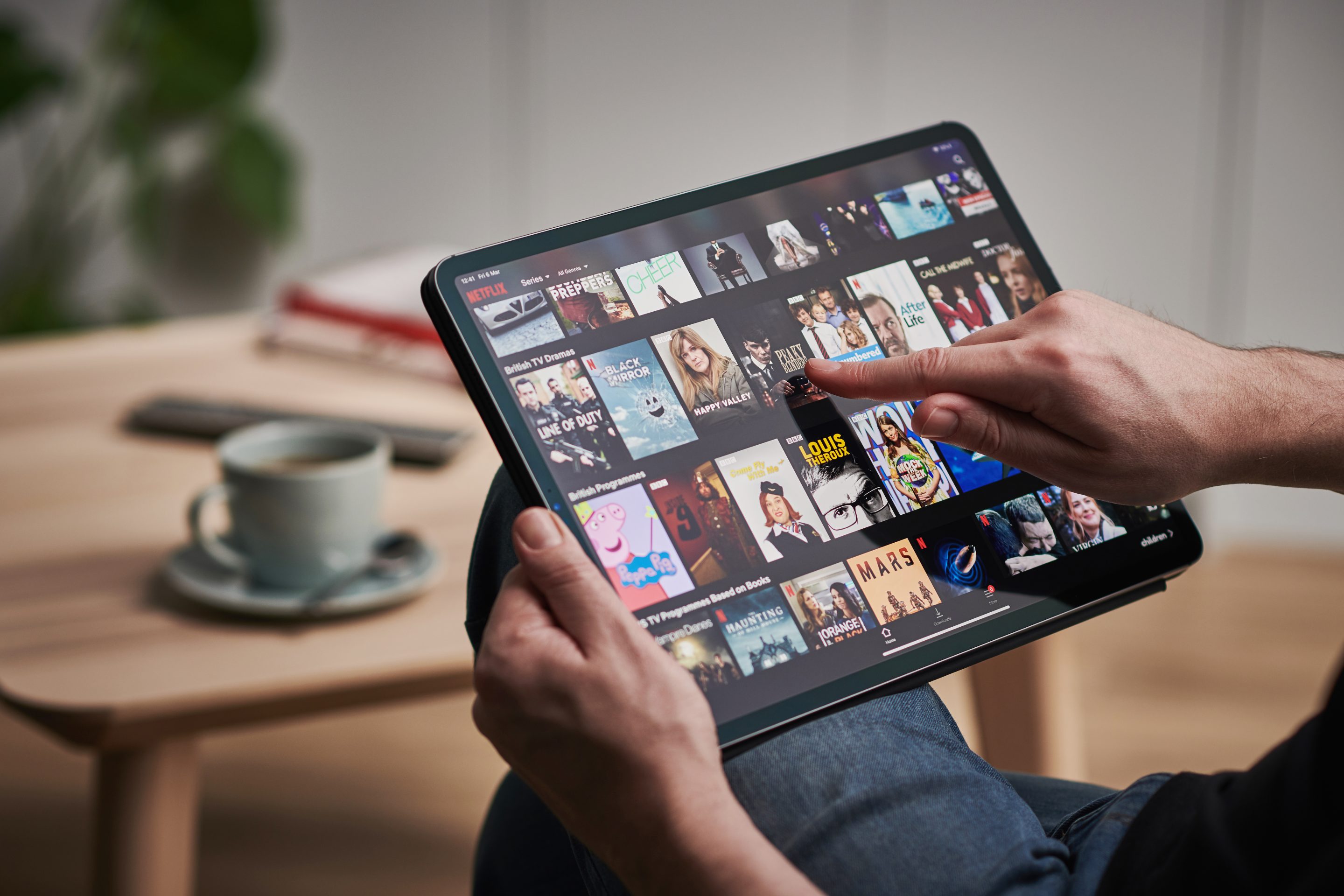 Detail of a mans hand scrolling through Netflix on an Apple iPad Pro, taken on March 6, 2020. 