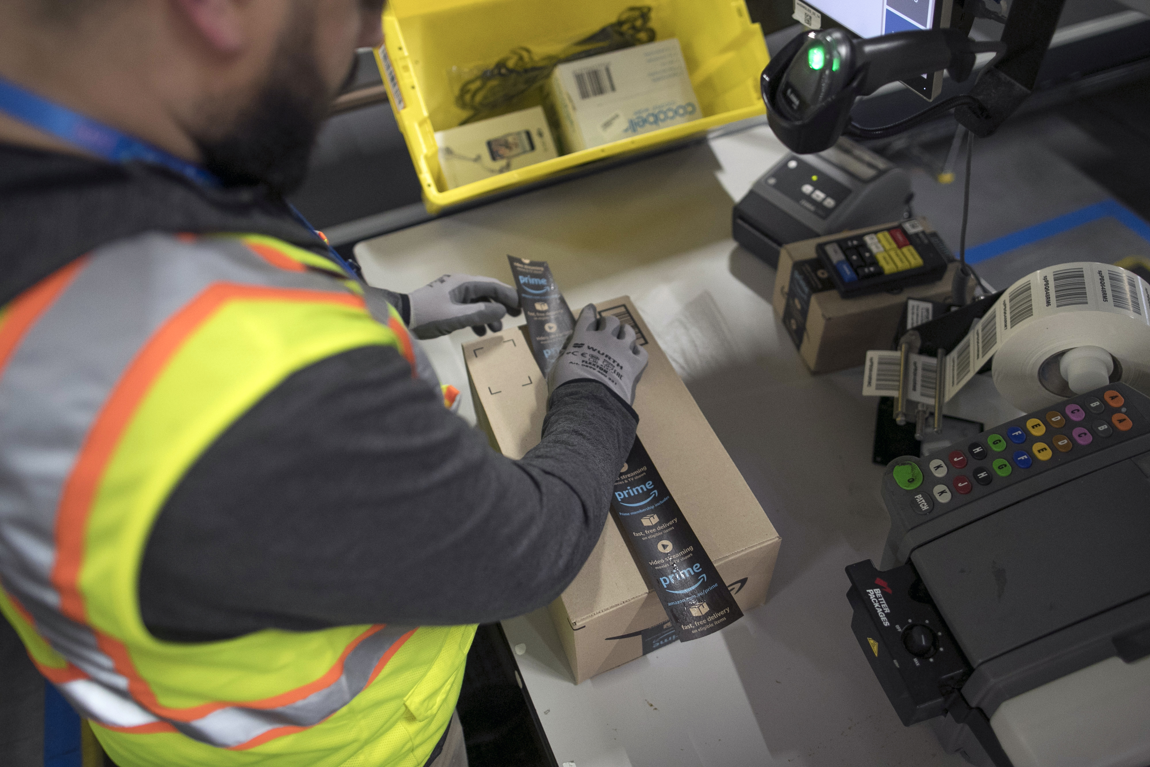 An employee seals a box at an Amazon.com Inc. fulfillment center.