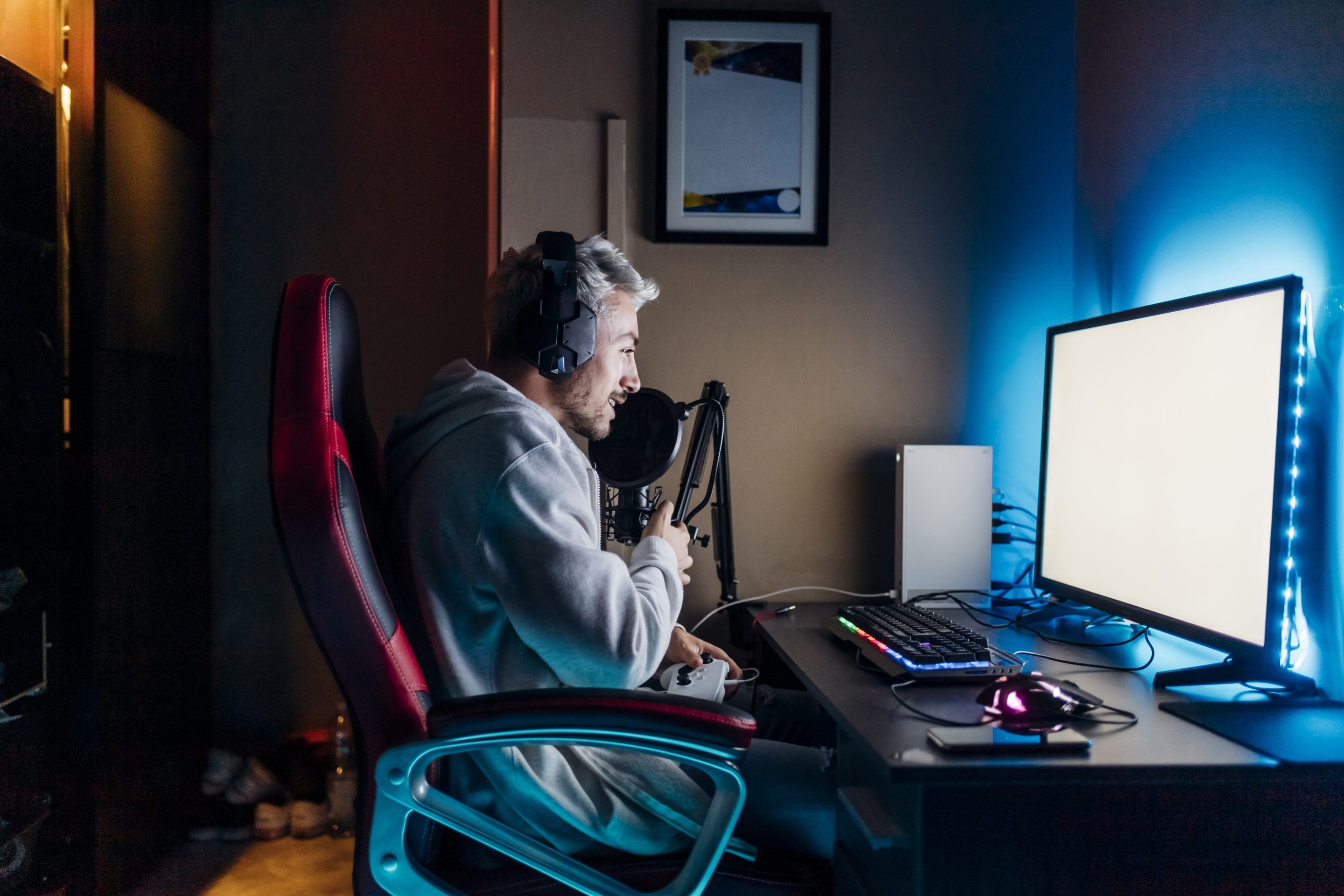 A livestreamer speaks into a microphone while streaming on his computer