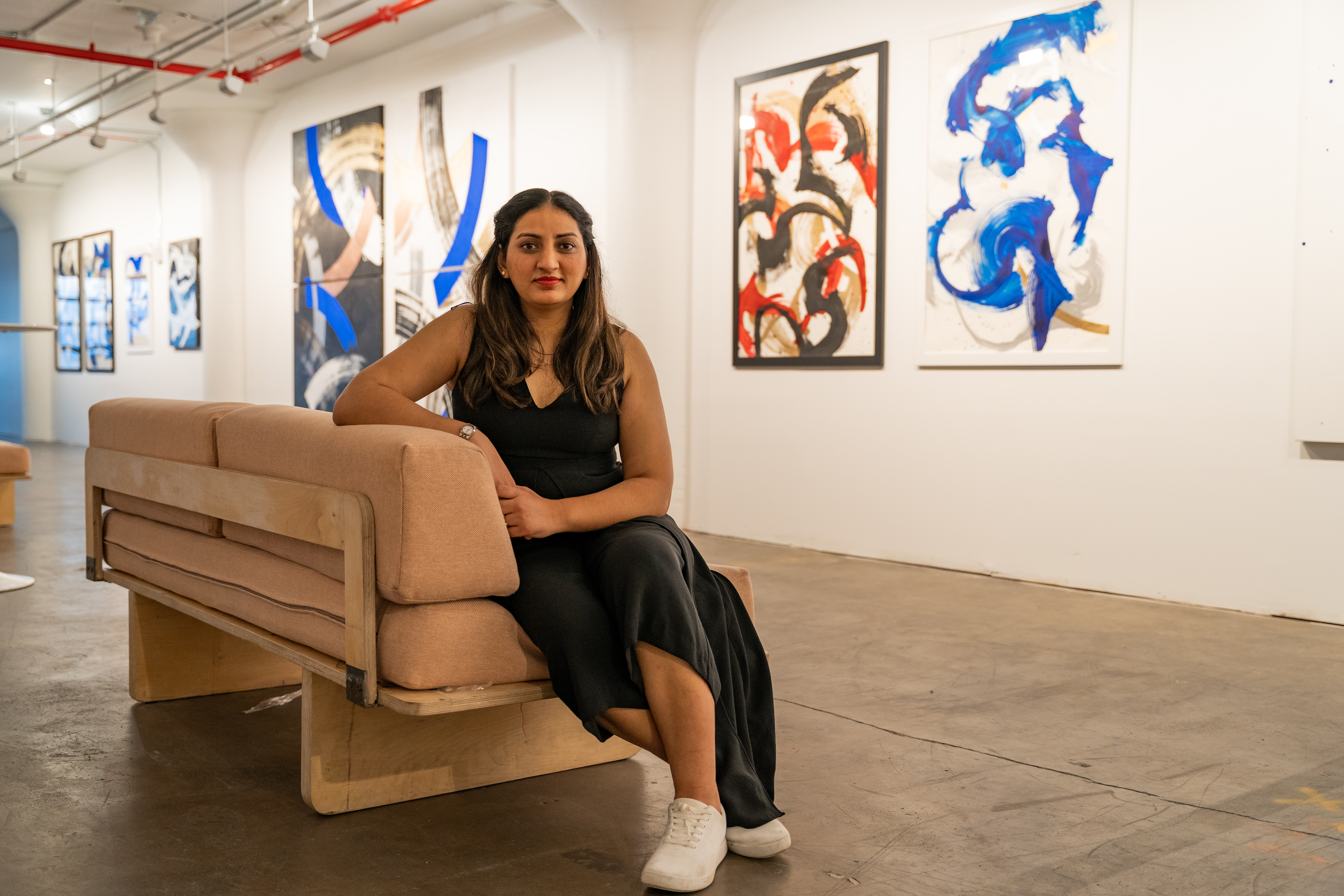 Sidra Qasim, now Atom's CEO, sits in the startup's art gallery in Brooklyn Navy Yard, sporting a pair of Atoms sneakers.