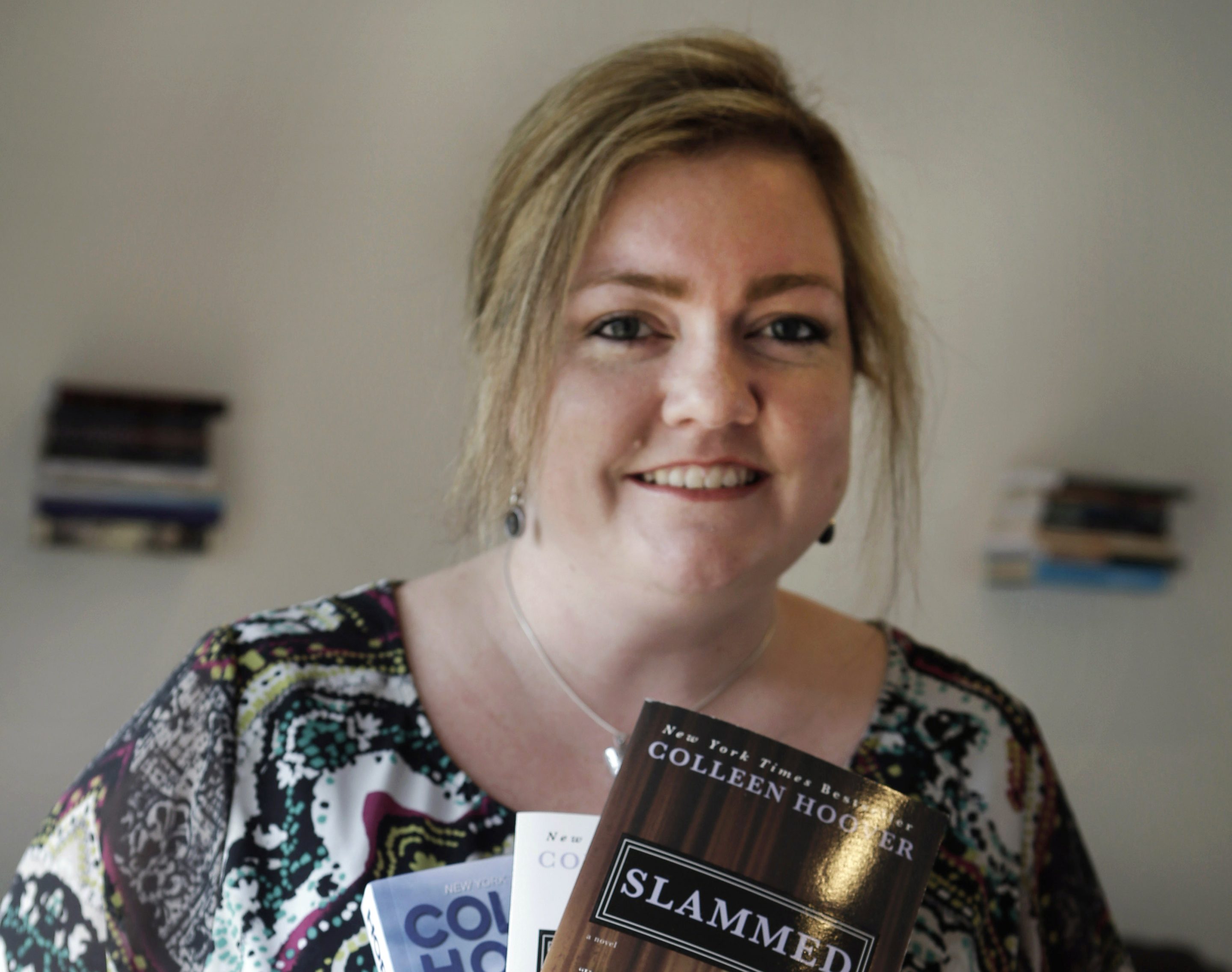 A woman smiling holding books
