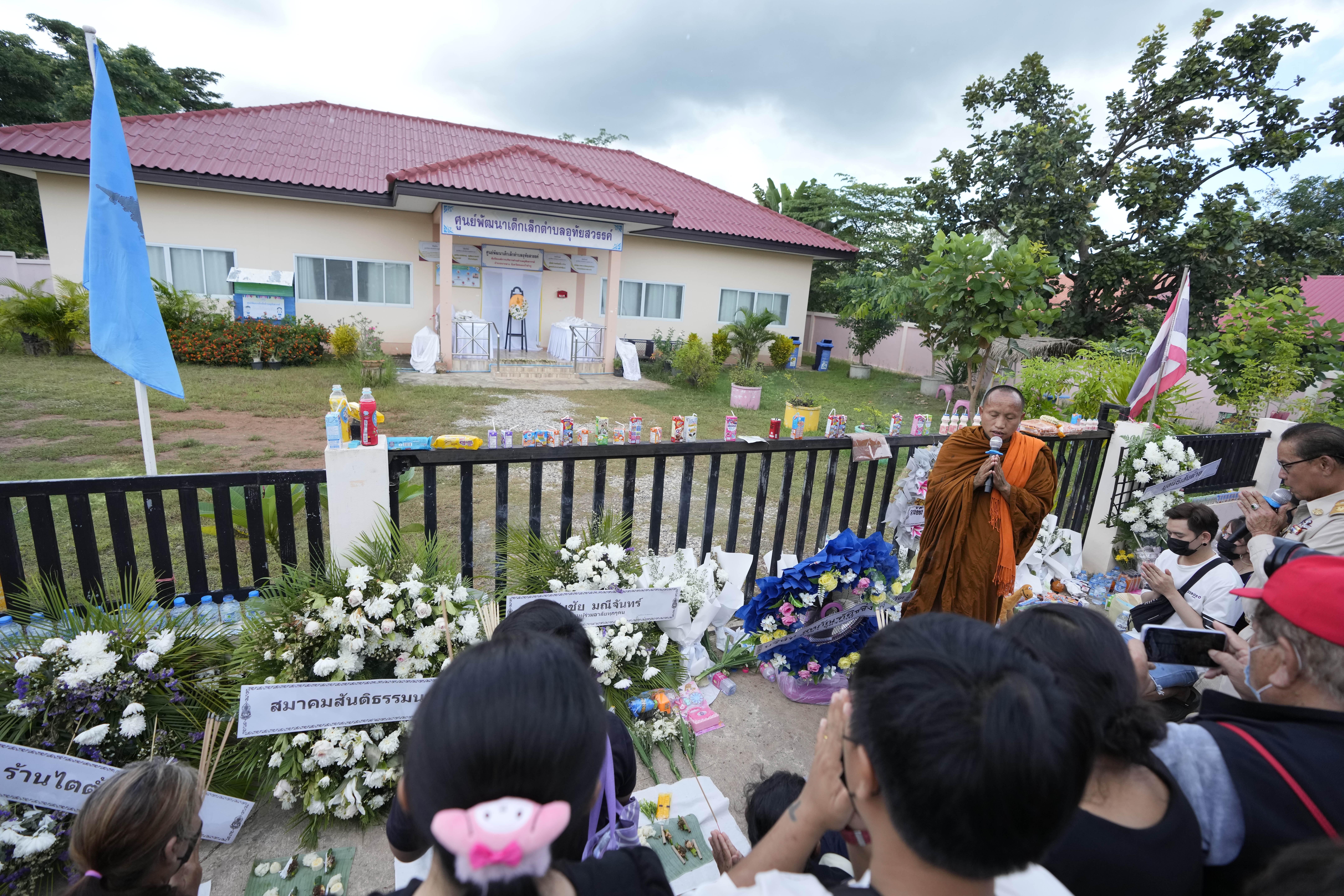 Buddhist pray with relatives of the victims of a mass killing attack gather for a Buddhist ceremony front on the Young Children's Development Center in the rural town of Uthai Sawan, north eastern Thailand, on Oct. 9, 2022. 