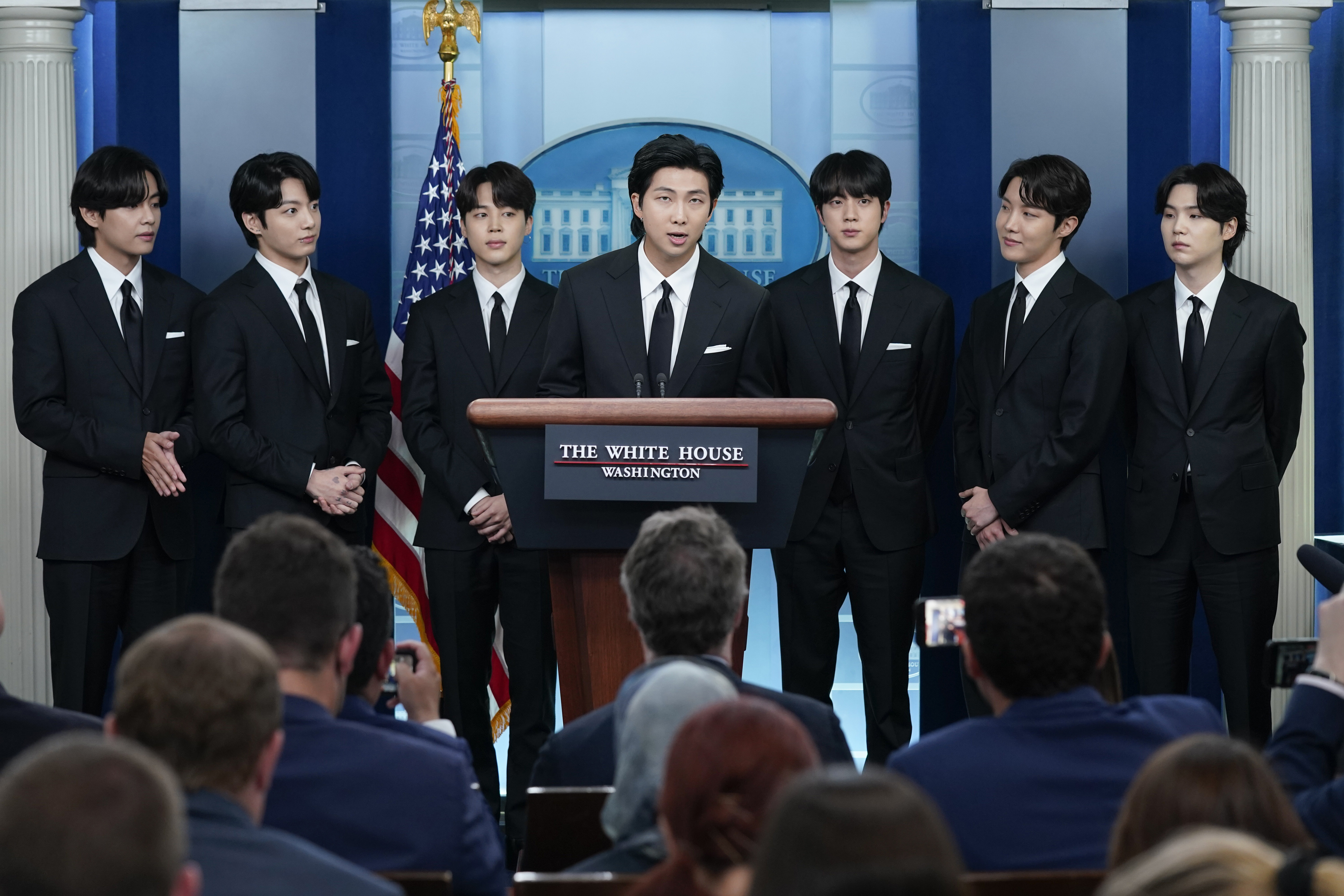 RM, center, accompanied by other K-pop supergroup BTS members from left, V, Jungkook, Jimin, Jin, J-Hope, and Suga speaks during the daily briefing at the White House in Washington, May 31, 2022.