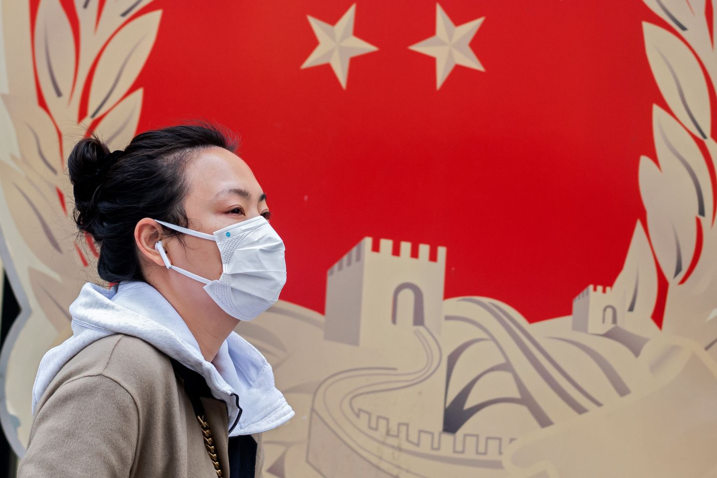 A woman walking in front of a mural.