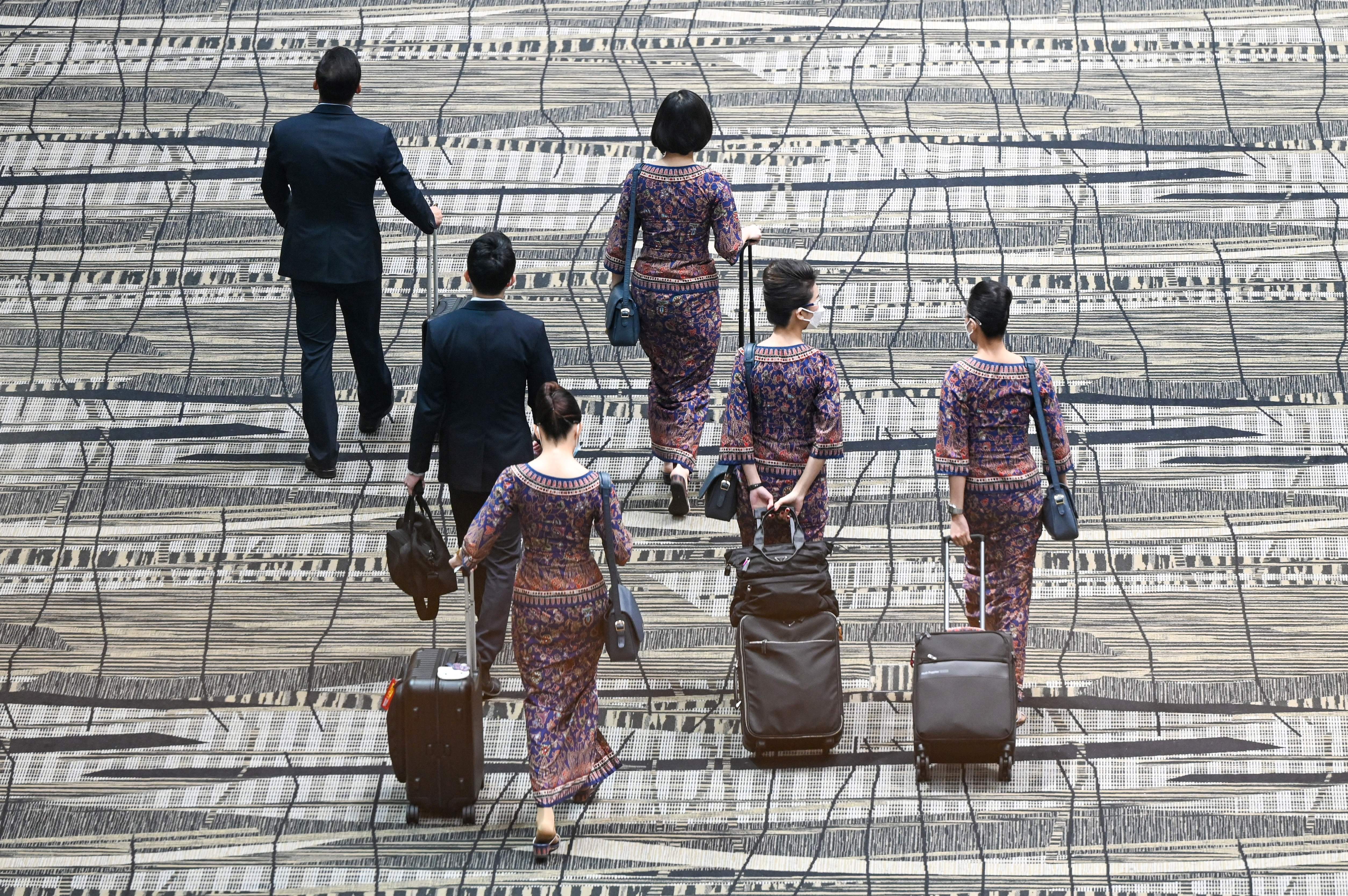 Singapore Airlines crew walk through the transit hall of Singapore Changi Airport in Singapore on Jan. 12, 2022.