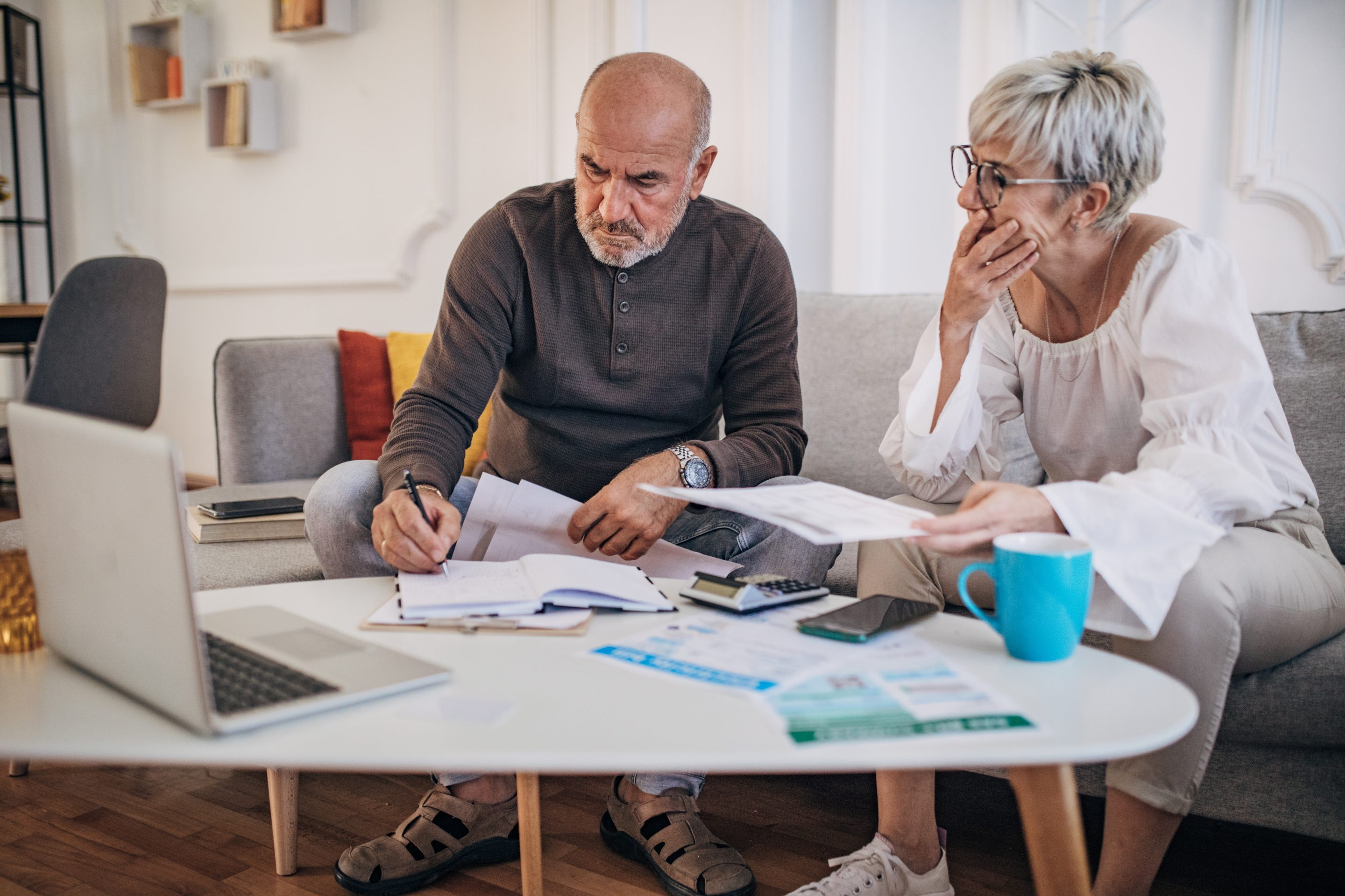 Couple calculating bills and taxes and home and trying to organise to pay them