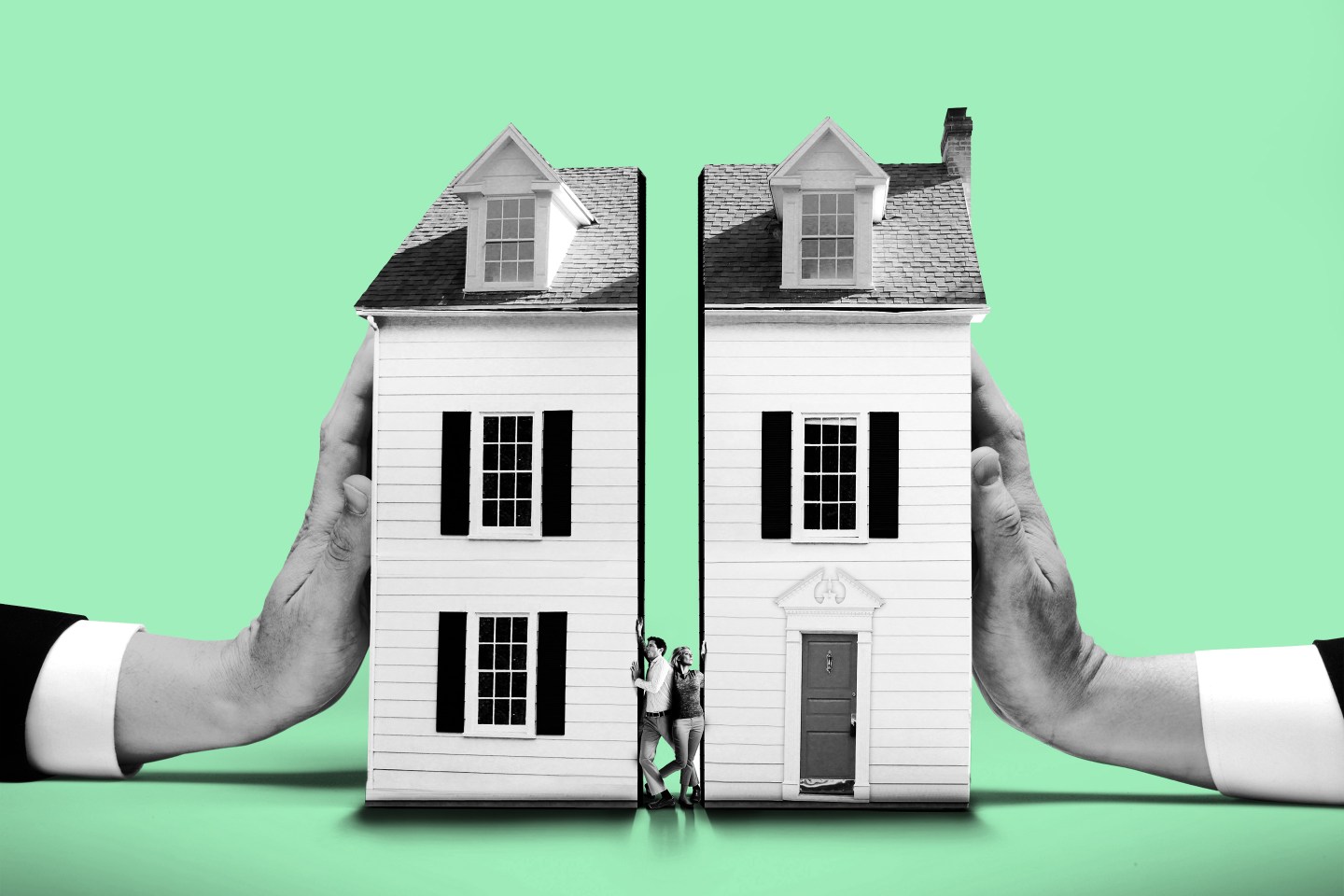 Couple squeezed between houses pushed by large hands
