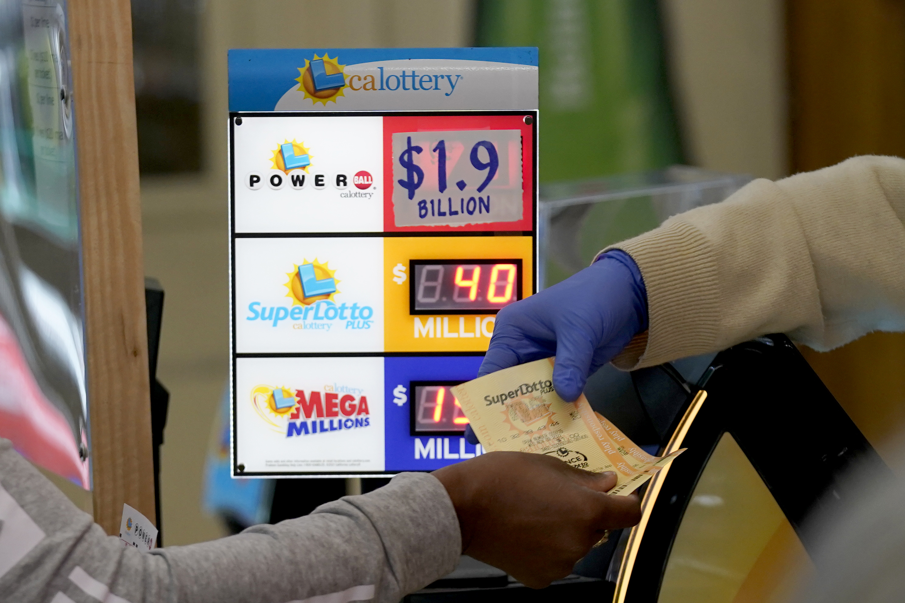 A customer is handed Powerball tickets purchased at Lichine's Liquor &; Deli in Sacramento, Calif., Nov. 7, 2022.