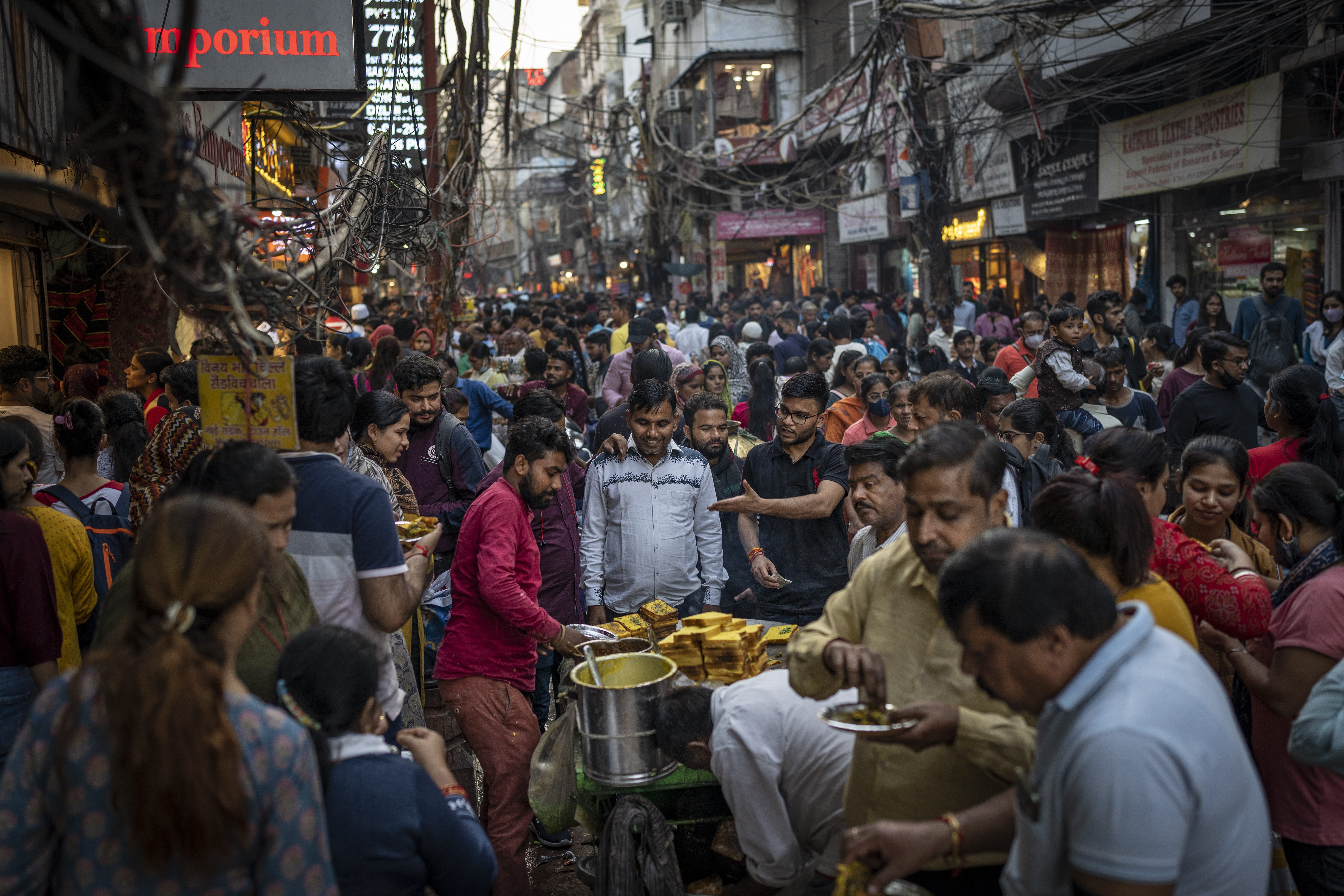 People eat street food as shoppers crowd a market in New Delhi, India, Nov. 12, 2022. The world's population is projected to hit an estimated 8 billion people on Nov. 15, according to a UN projection.