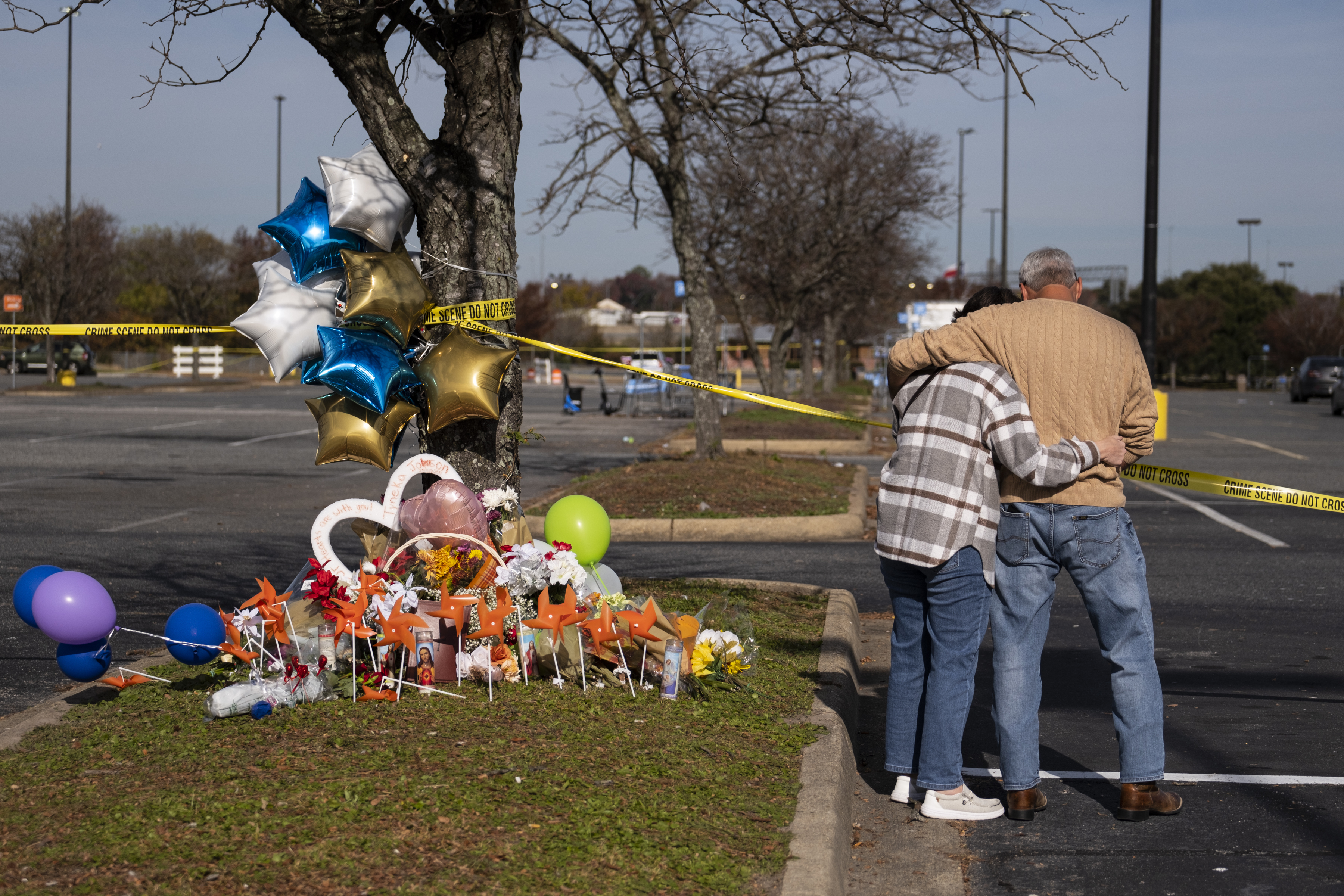 Debbie, left, and Chet Barnett place flowers at a memorial outside of the Chesapeake, Va., Walmart on Nov. 24, 2022.