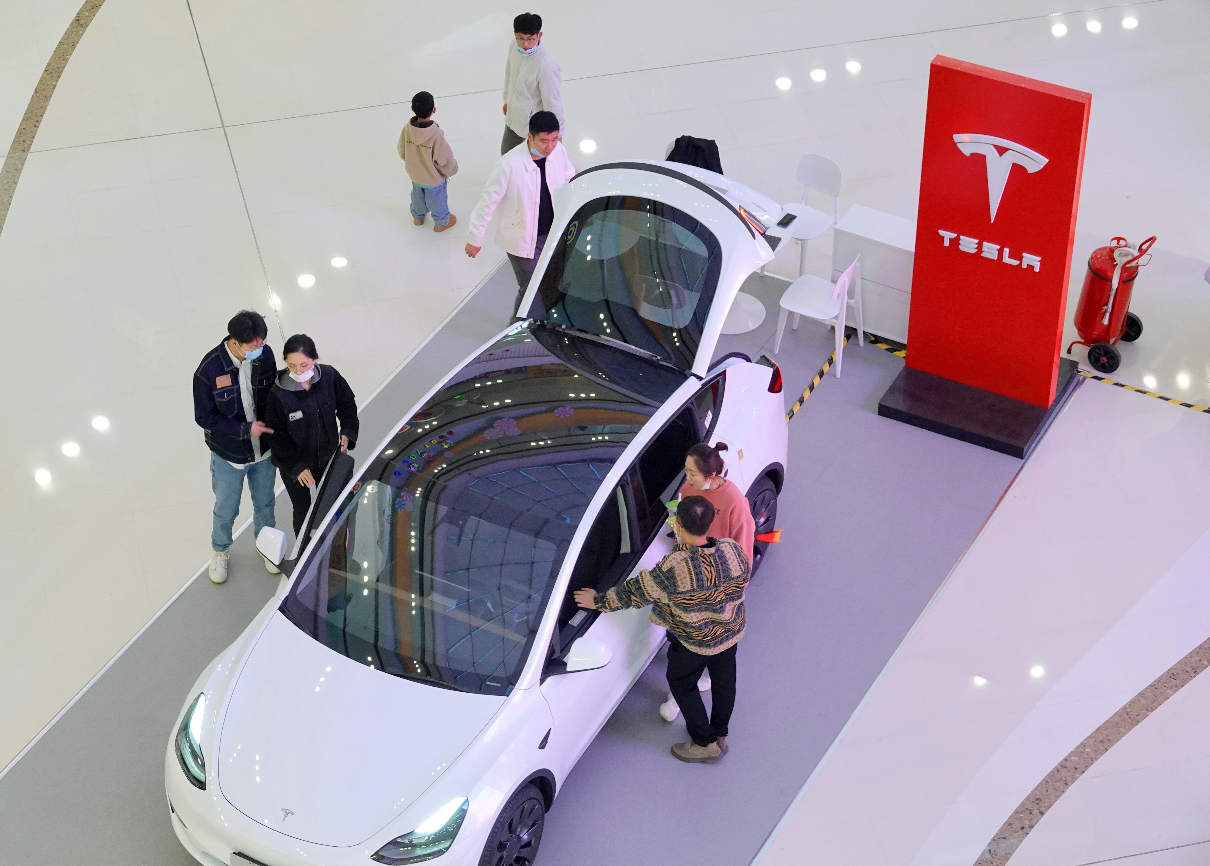 Customers learn about the Tesla Model Y at a mall in Yantai, Shandong Province, China, Oct 29, 2022. 