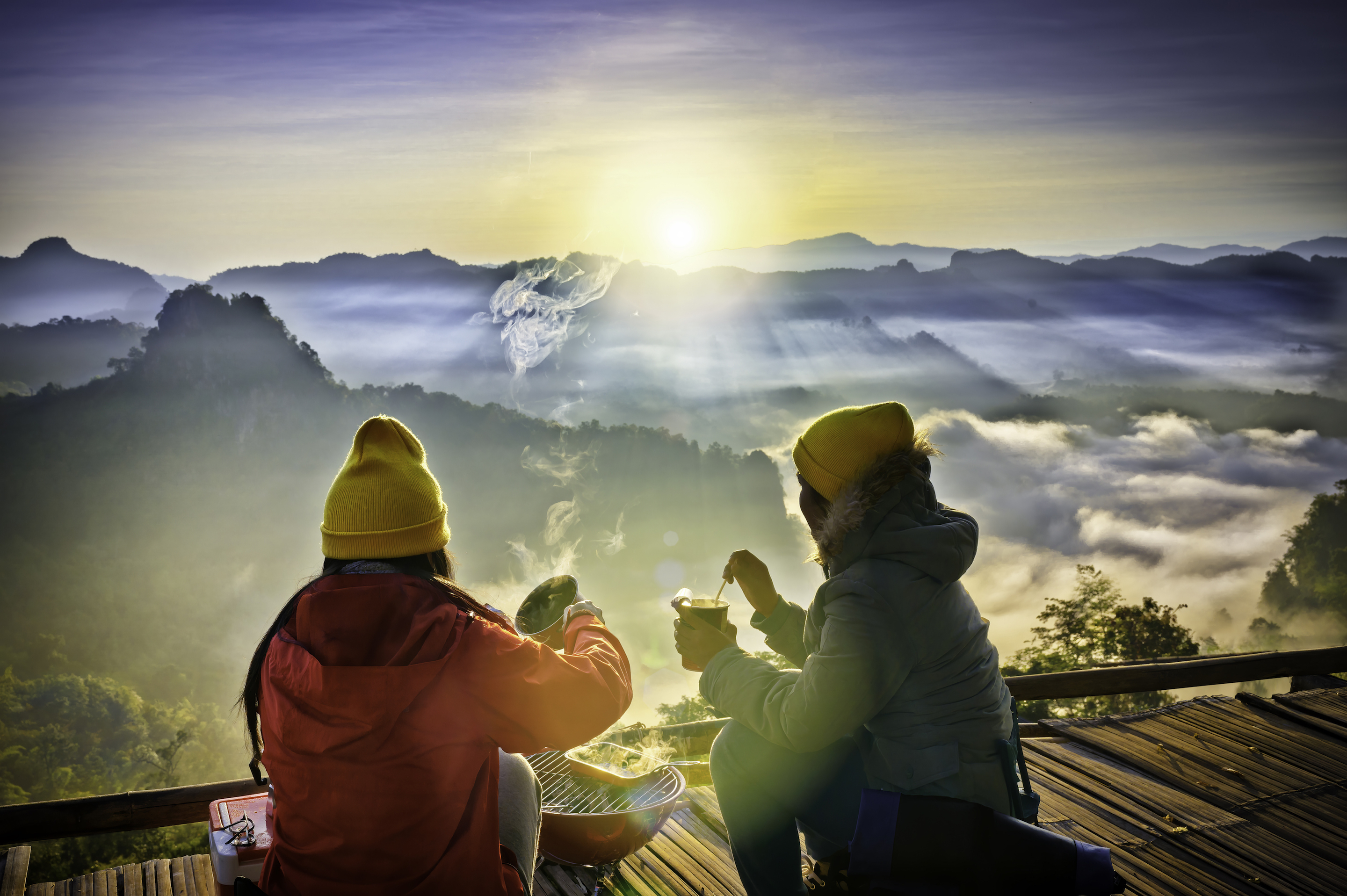 Travelers enjoying the sunrise while still keeping warm.