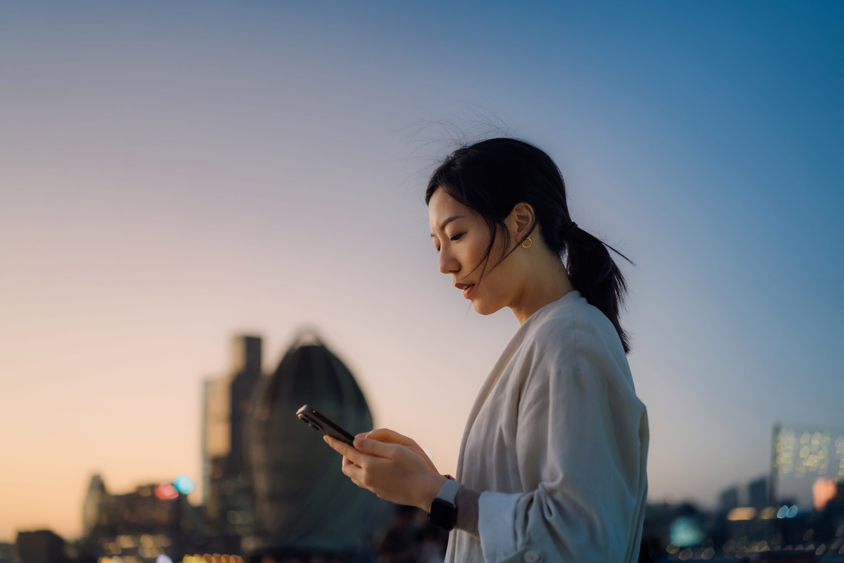 A young woman looks at her smart phone