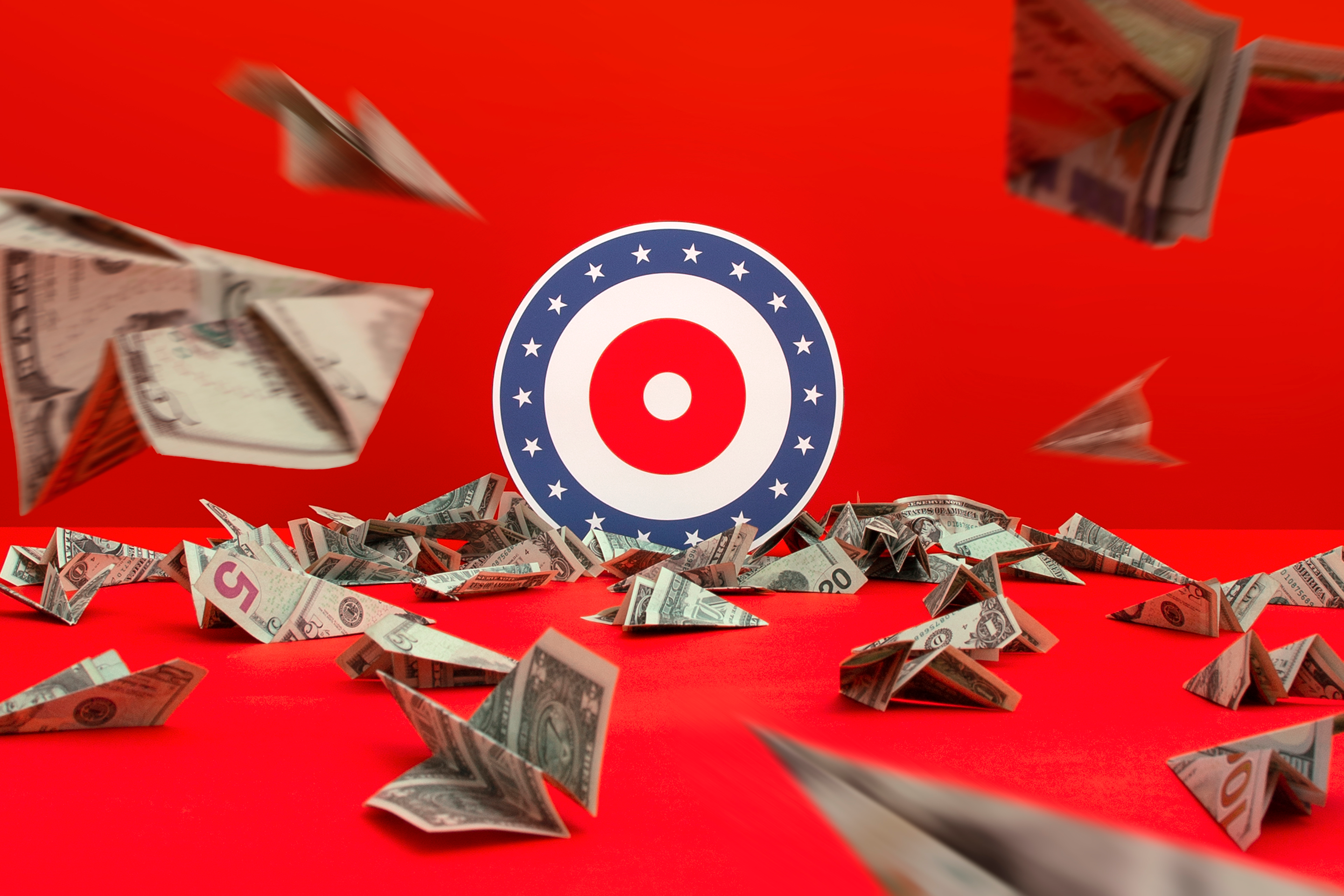 Dollar bills being folded into paper airplanes and thrown at a target.