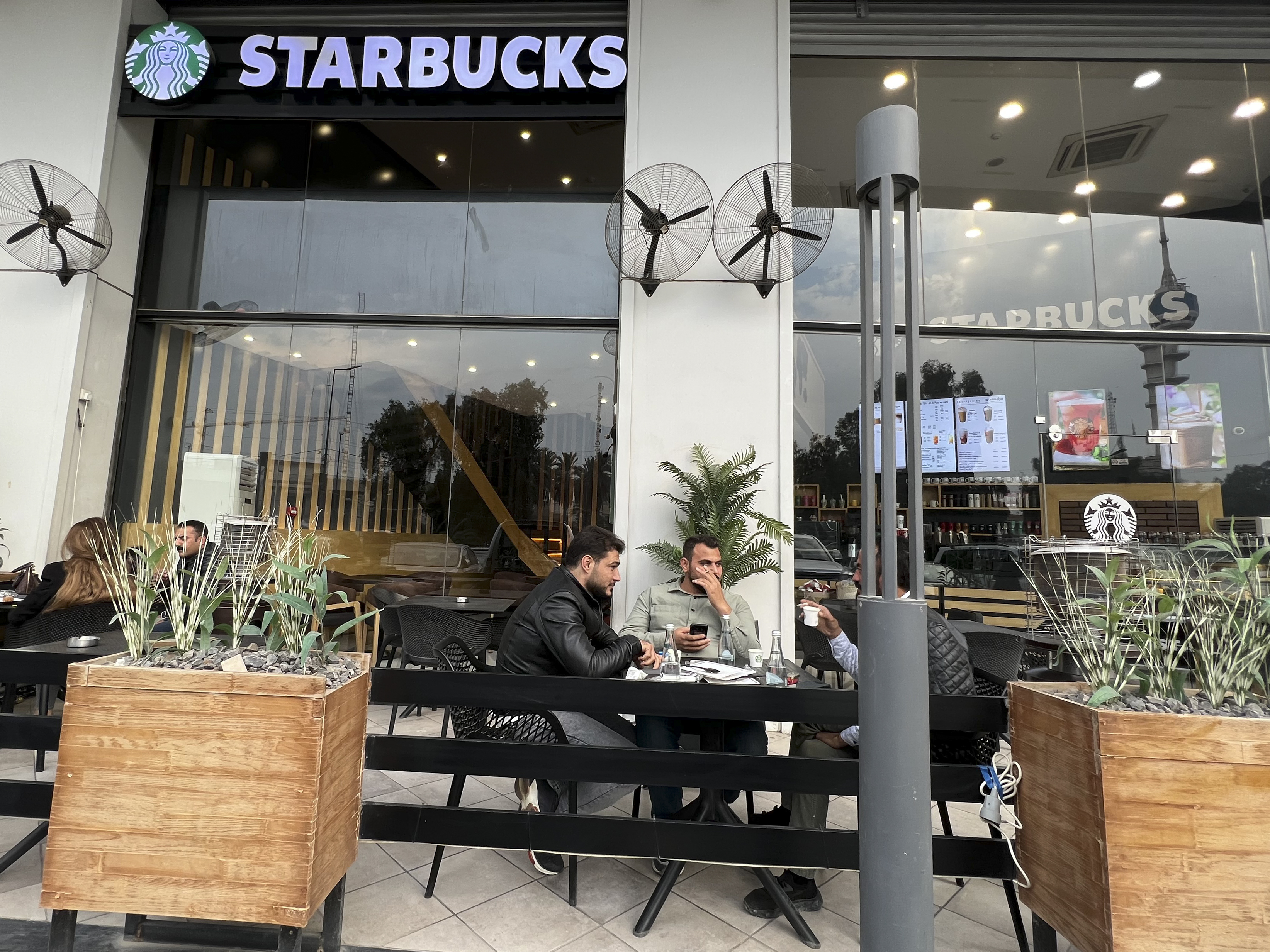 People sit in an unlicensed Starbucks cafe in Baghdad, Iraq, Dec. 21, 2022.
