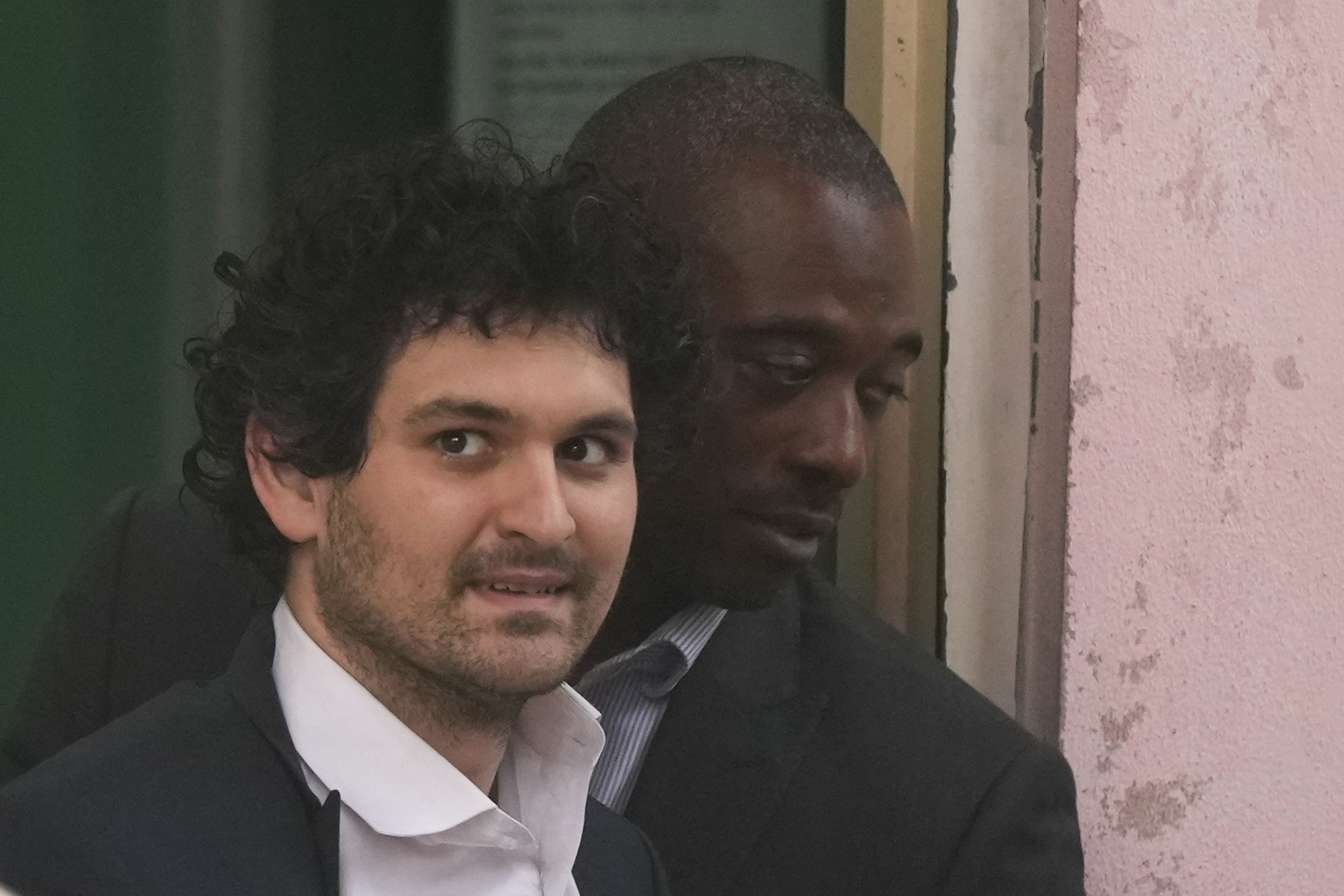 FTX founder Sam Bankman-Fried, is escorted from the Magistrate Court in Nassau, Bahamas, Dec. 21, 2022, after agreeing to be extradited to the U.S.