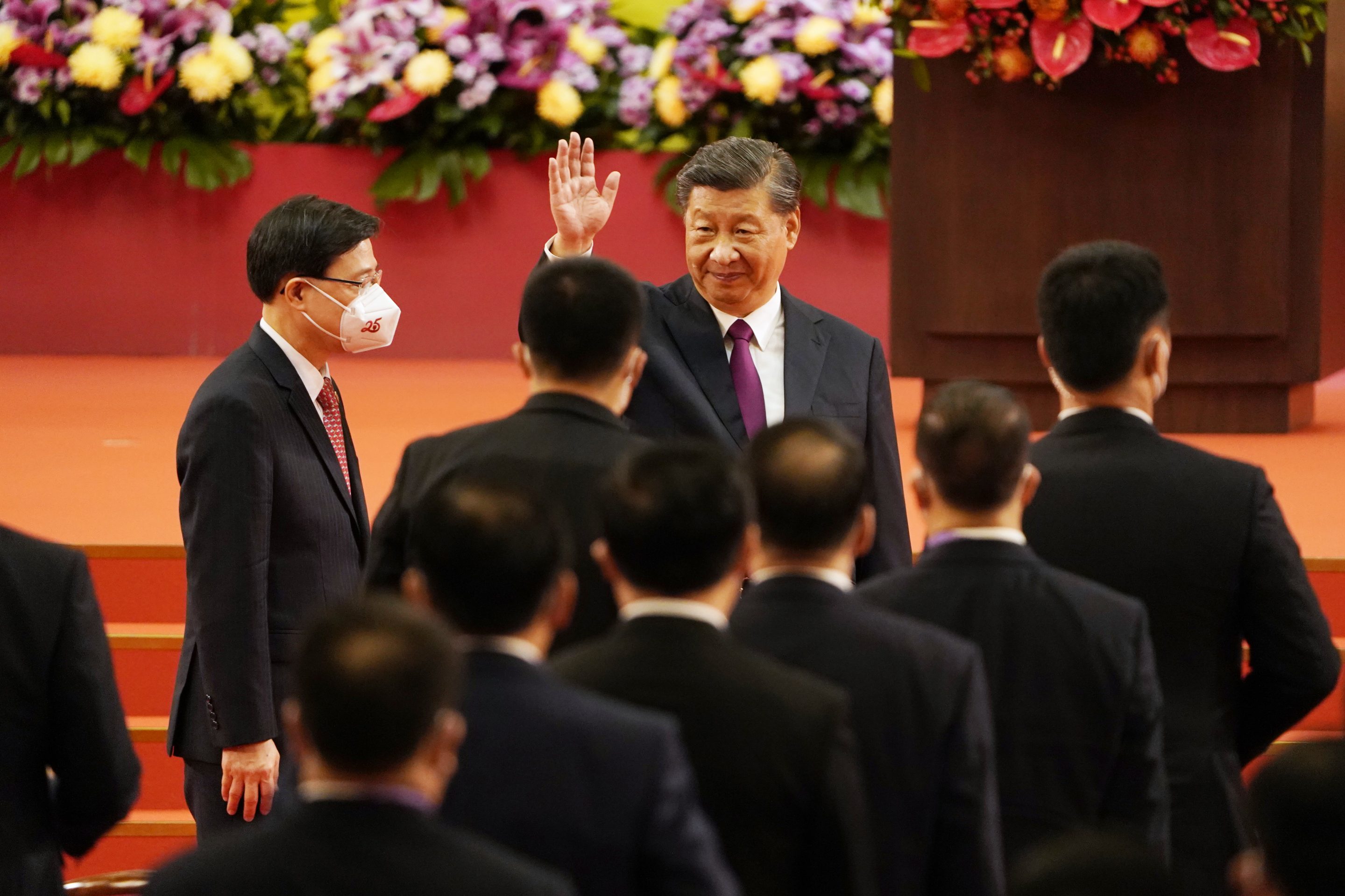 Chinese President Xi Jinping (center) waves after the swearing-in ceremony for John Lee (left) in Hong Kong on July 1, following a crackdown on pro-democracy opposition. 