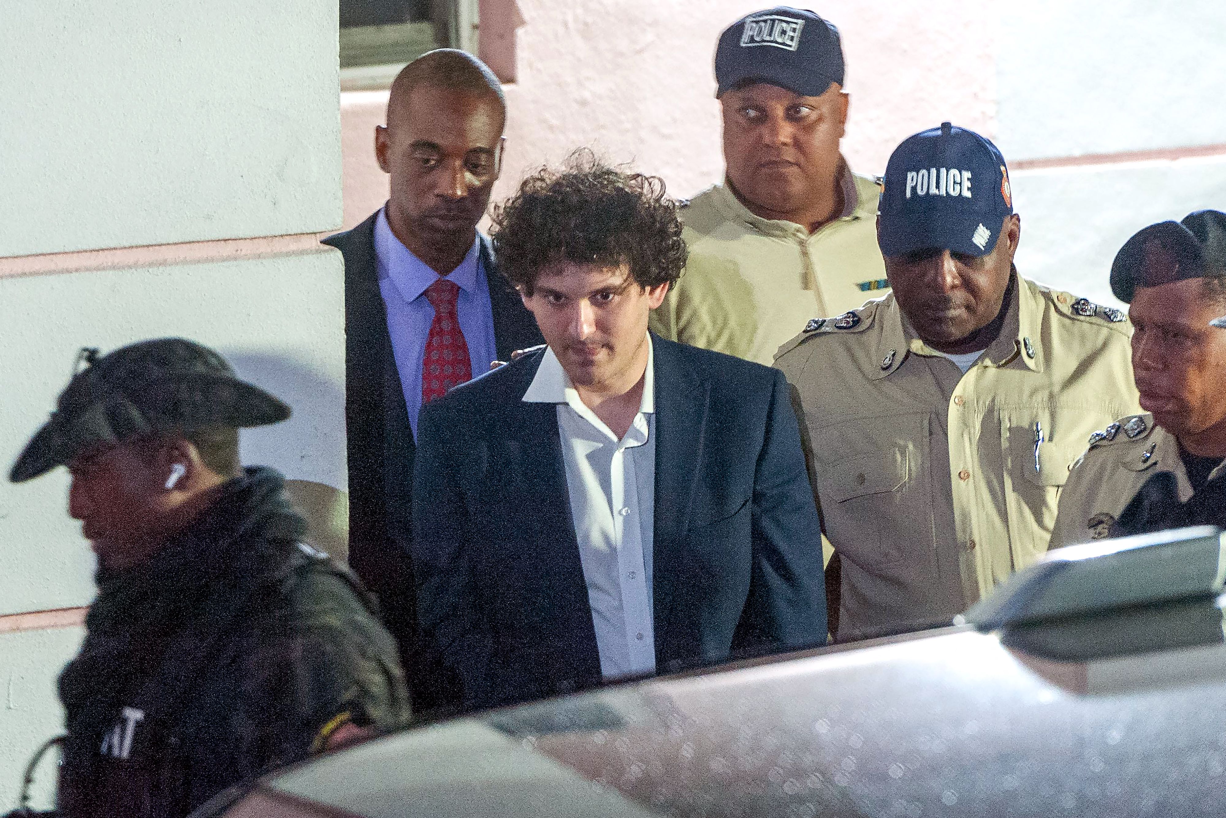 FTX founder Sam Bankman-Fried is led away handcuffed by officers of the Royal Bahamas Police Force in Nassau, Bahamas on Dec. 13, 2022.