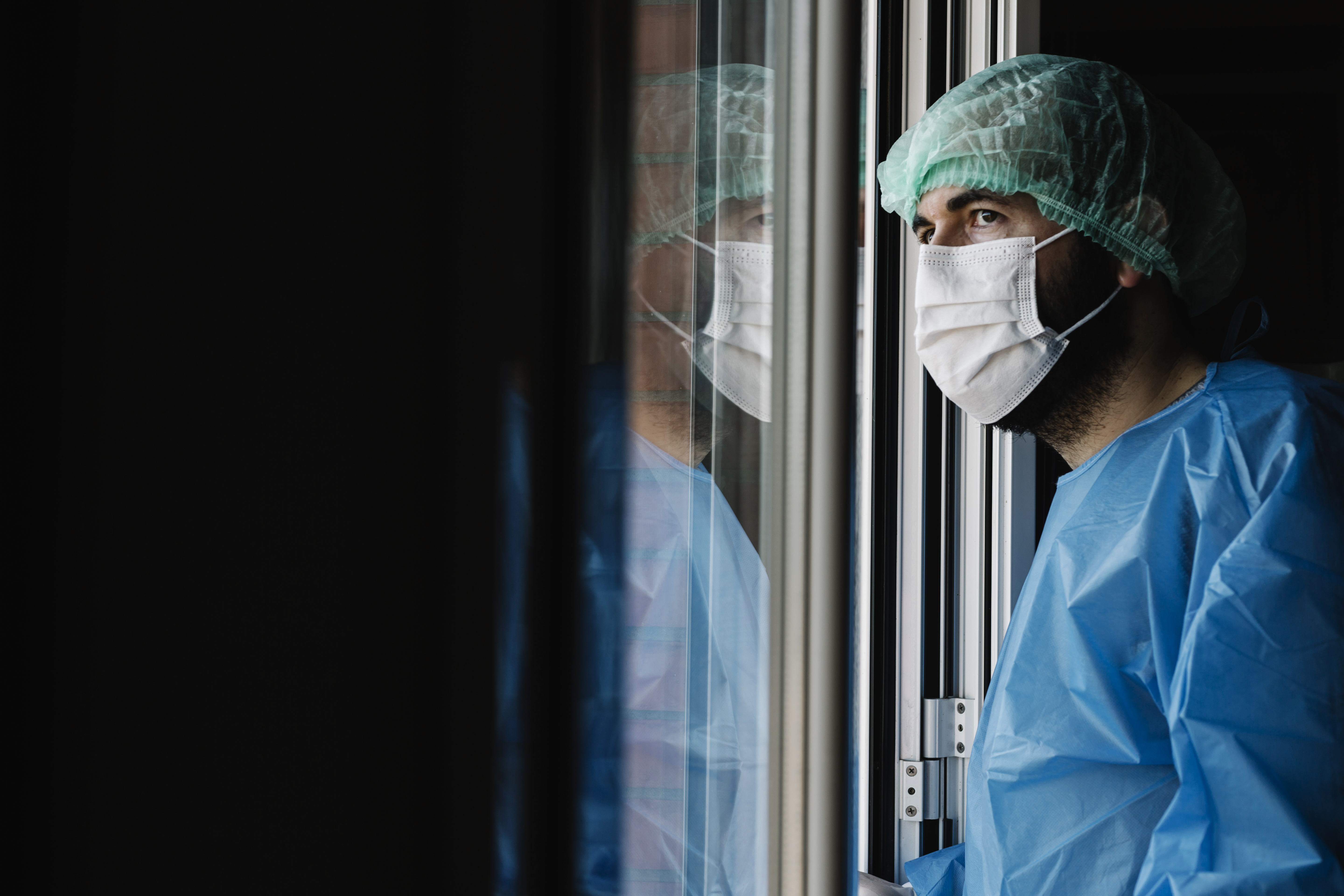 A doctor looking through a window.