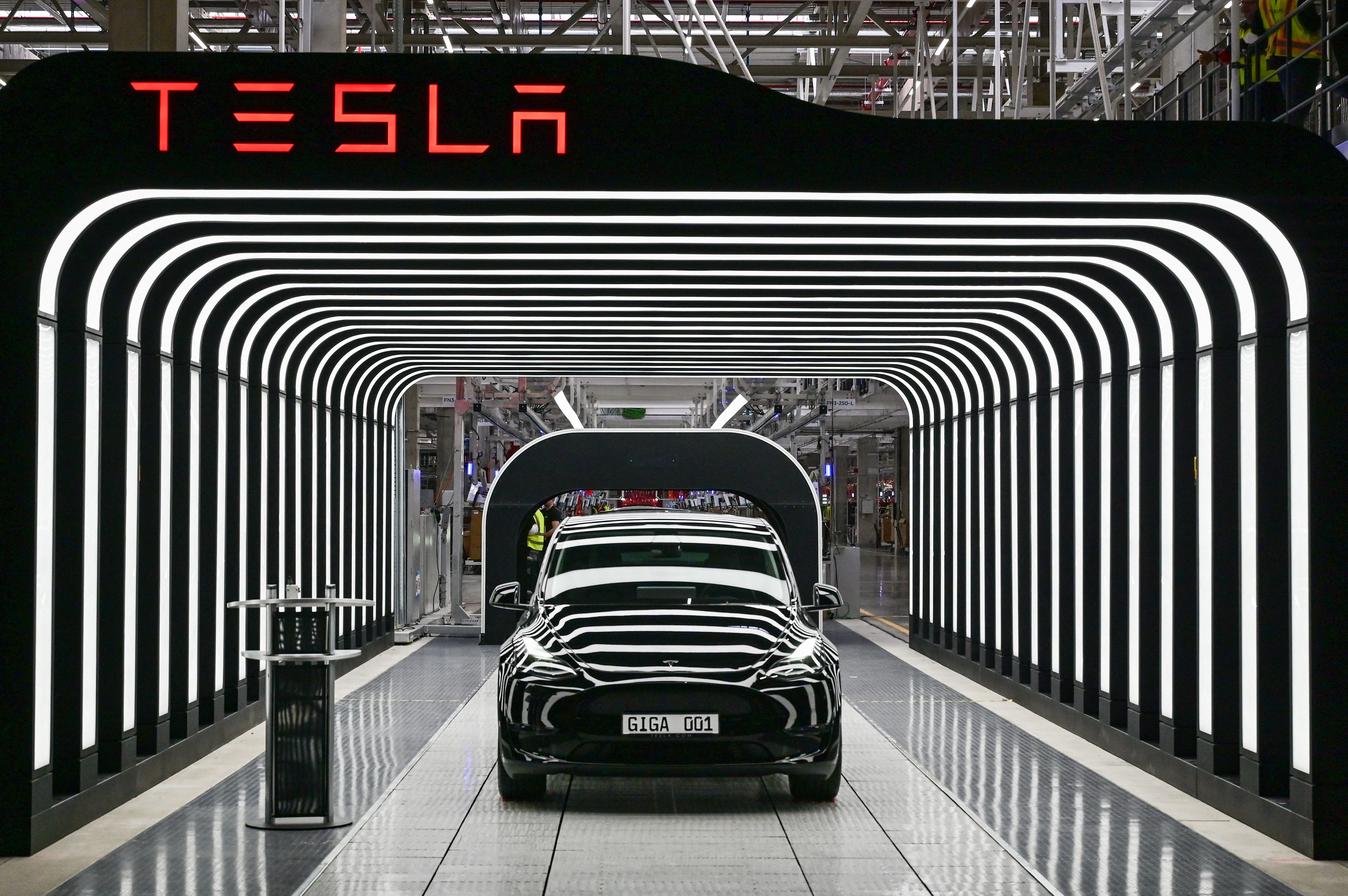 A black car is coming off the production line.