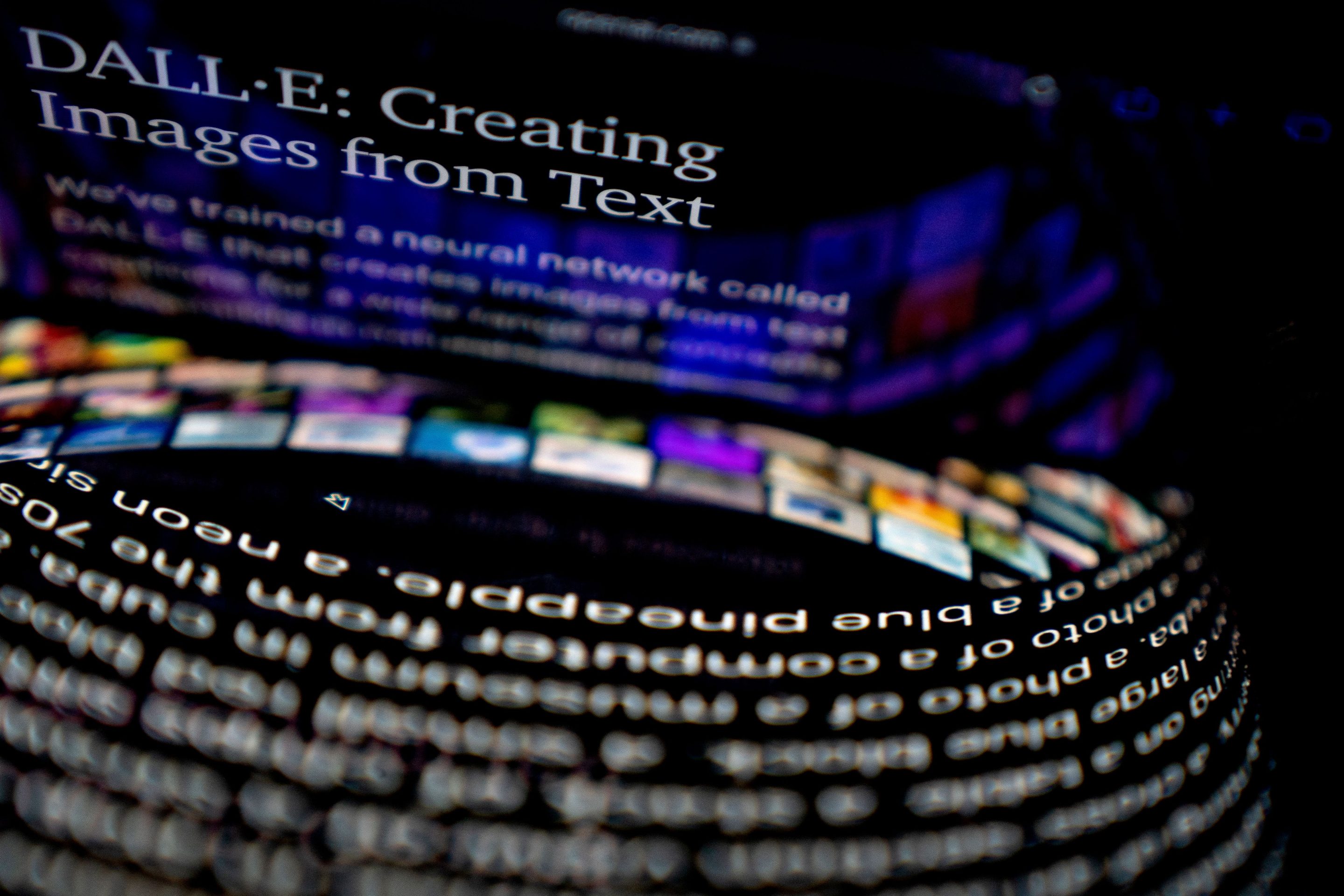 This photo illustration shows the DALL-E website reflected between a computer screen and cellphone.