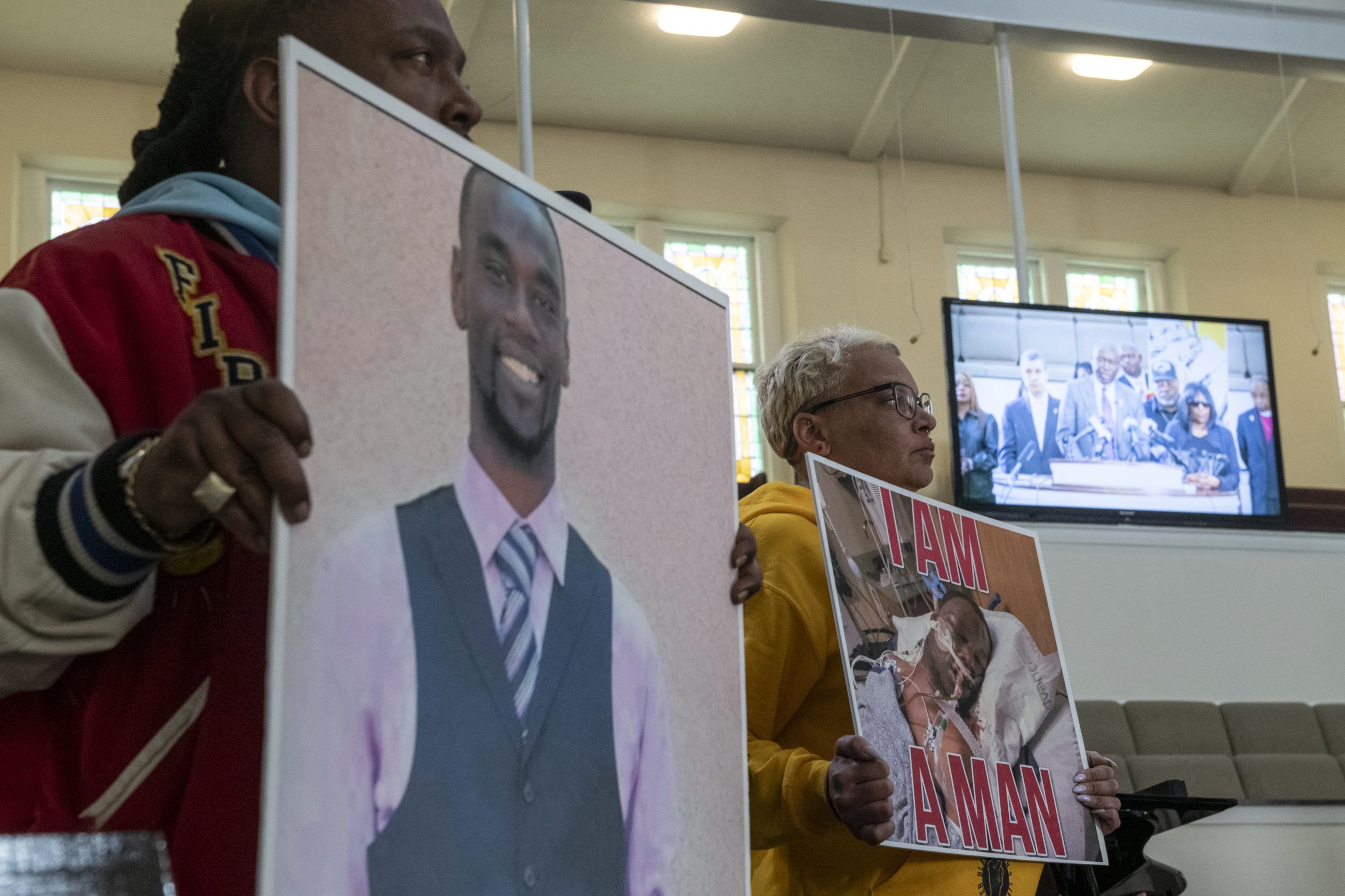 Activists hold signs showing Tyre Nichols.