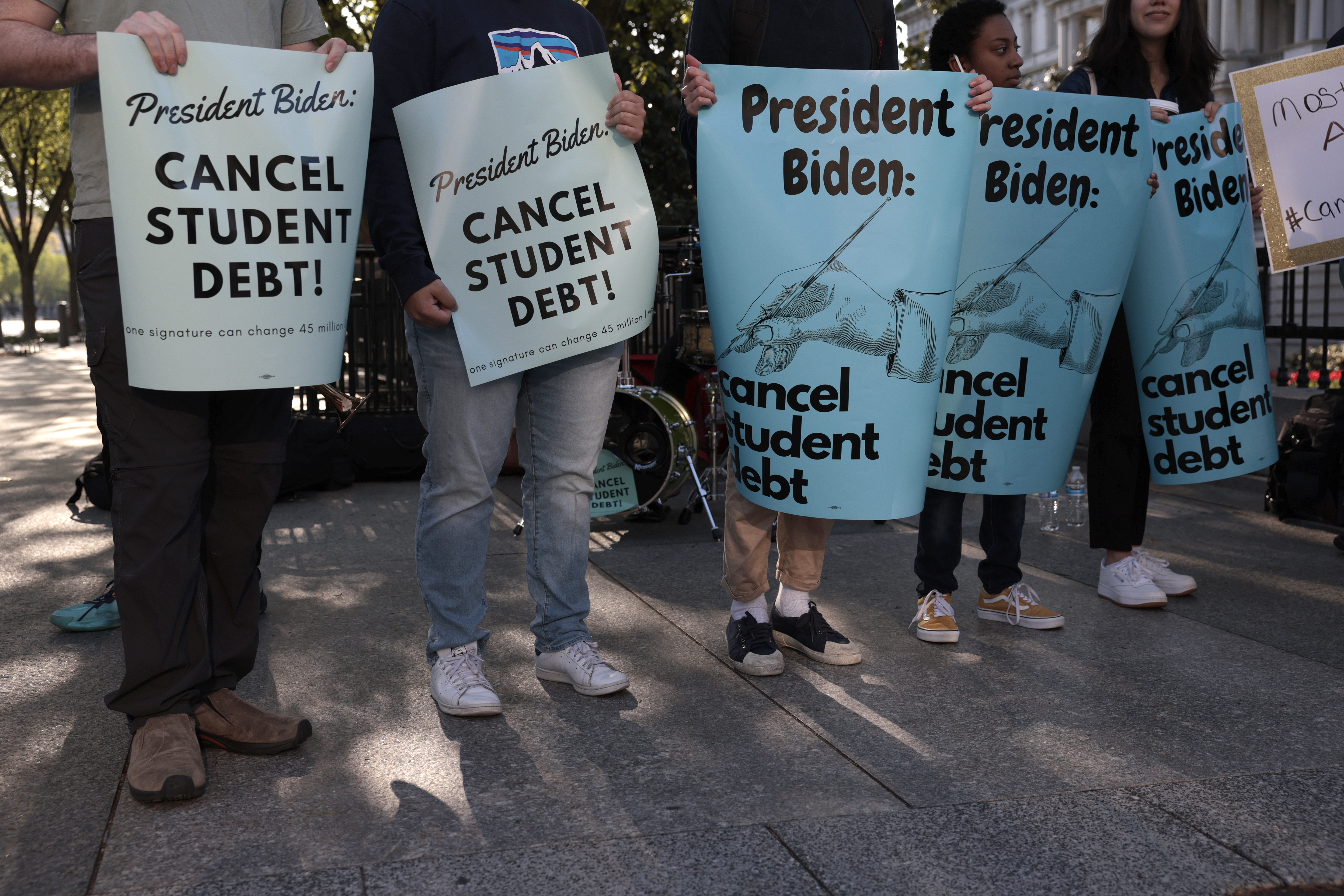 Student debt protesters holding signs.