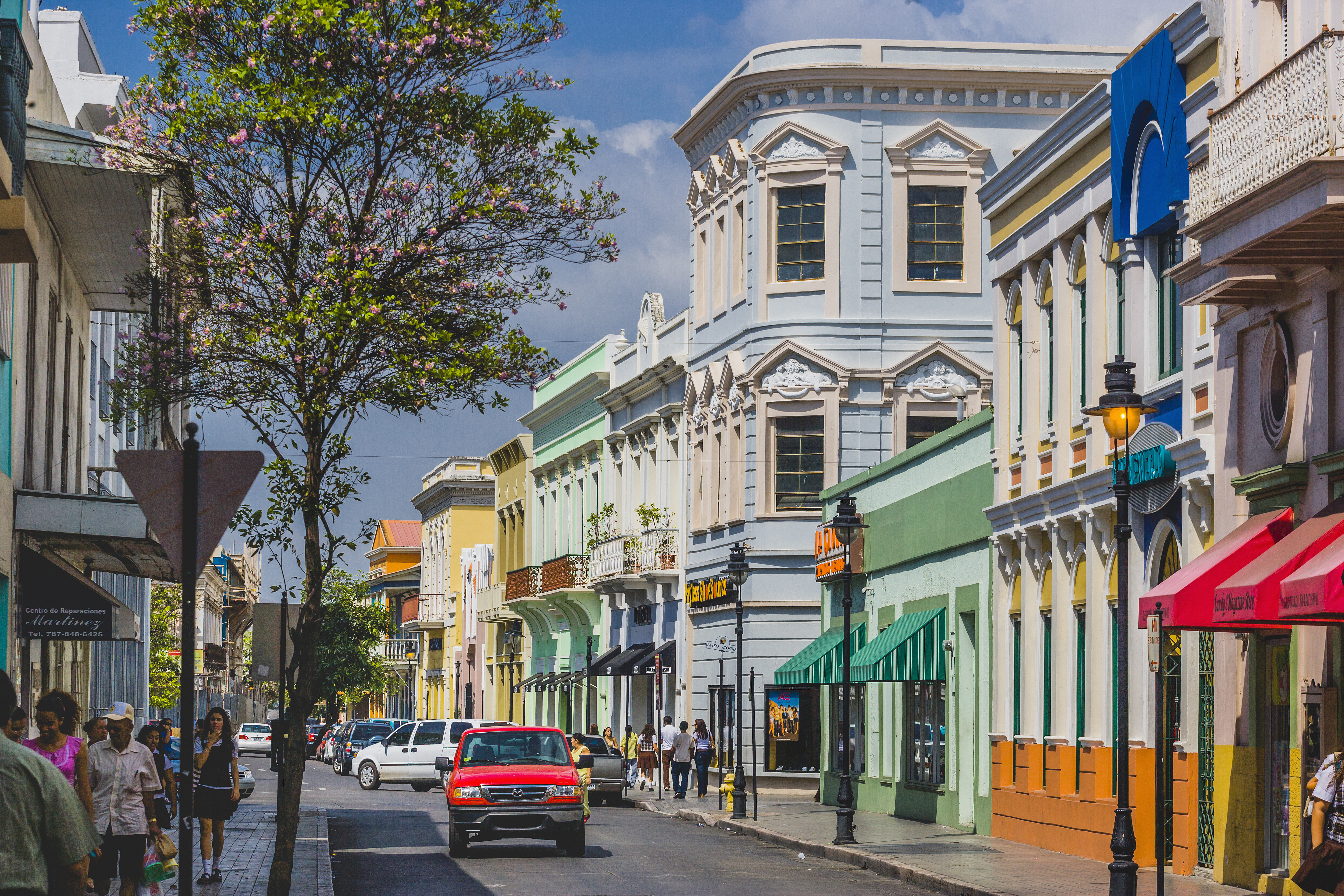 A car drives down a colorful street in Puerto Rico.