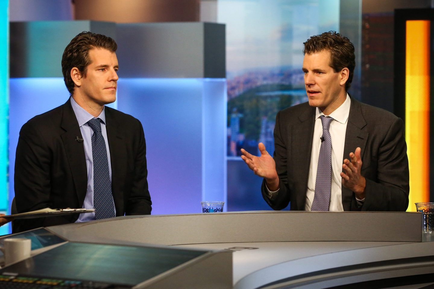 Cameron Winklevoss, president and co-founder of crypto exchange Gemini, right, speaks as Tyler Winklevoss, chief executive officer and co-founder of Gemini, listens during a Bloomberg Television interview in New York, U.S., on Tuesday, Dec. 12, 2017.