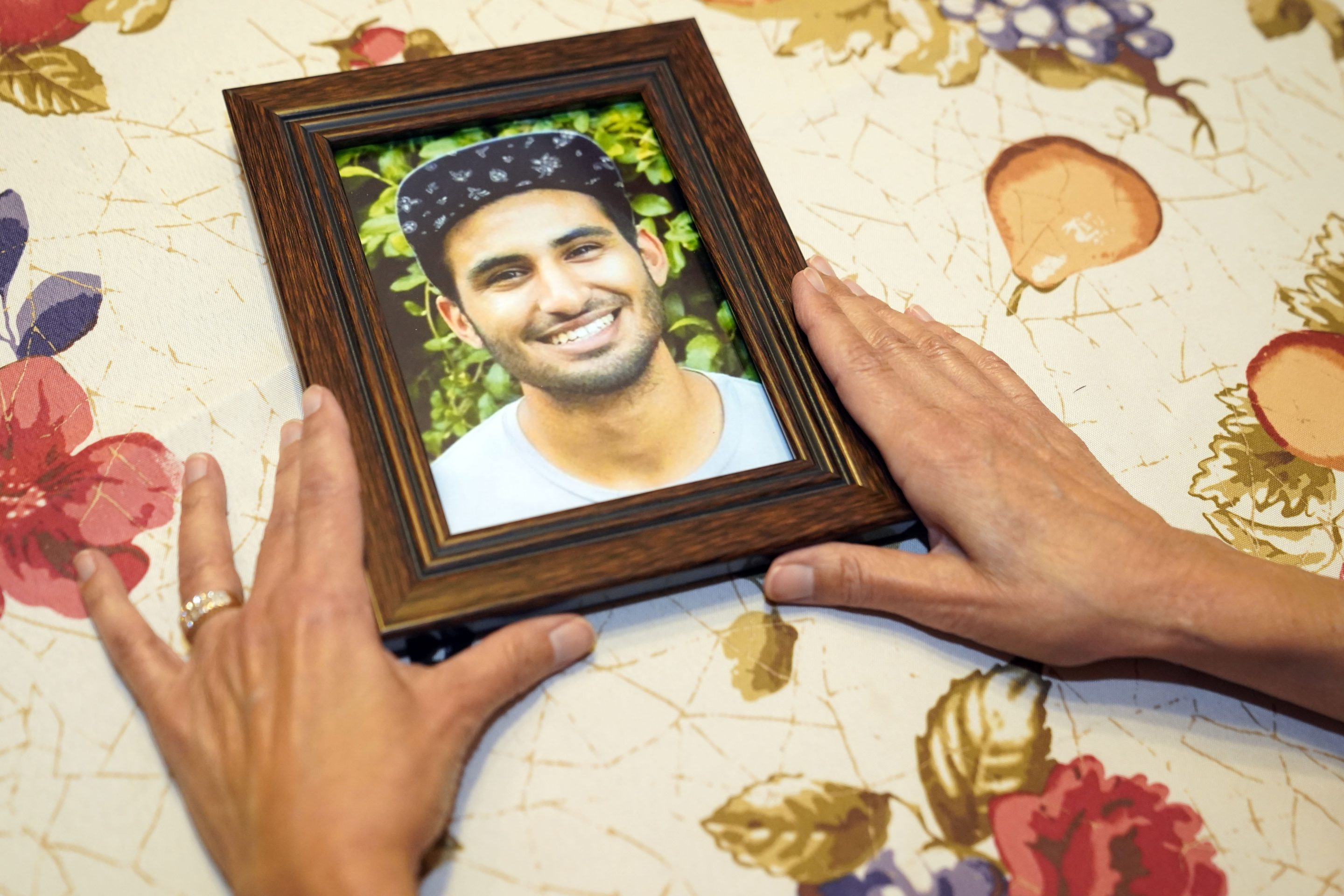 Dolores Cruz shows a photo of her youngest son, Eric Cruz, on Wednesday at her home in San Gabriel, Calif. Cruz published an essay in 2022 about grieving for her son, who died in a car crash in 2017. "Died Suddenly" used a screenshot of the headline in the film, portraying his death as vaccine related.