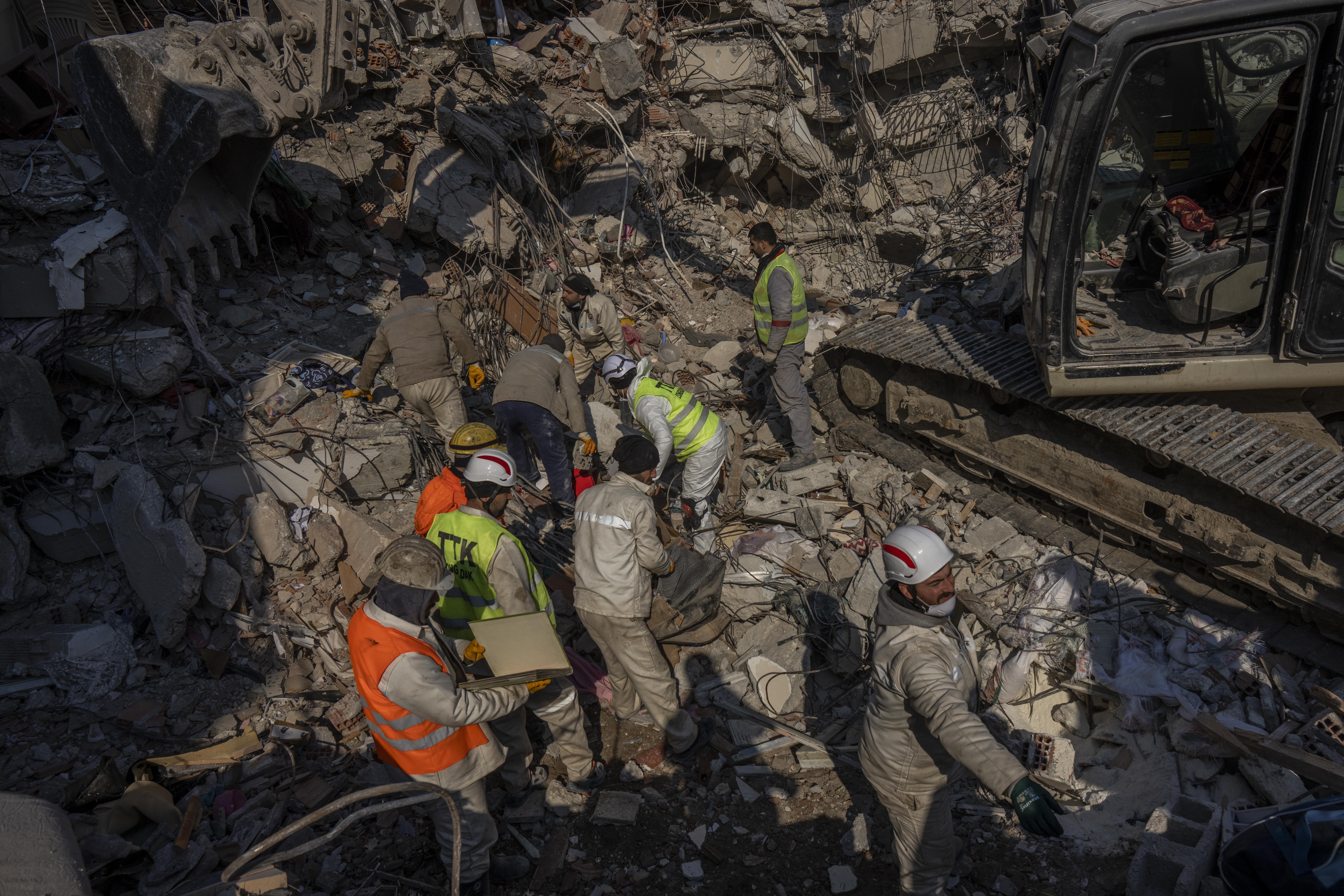 Members of a search and rescue team work on a collapsed structure after the earthquake in Antakya, southeastern Turkey, Sunday, Feb. 12, 2023. 