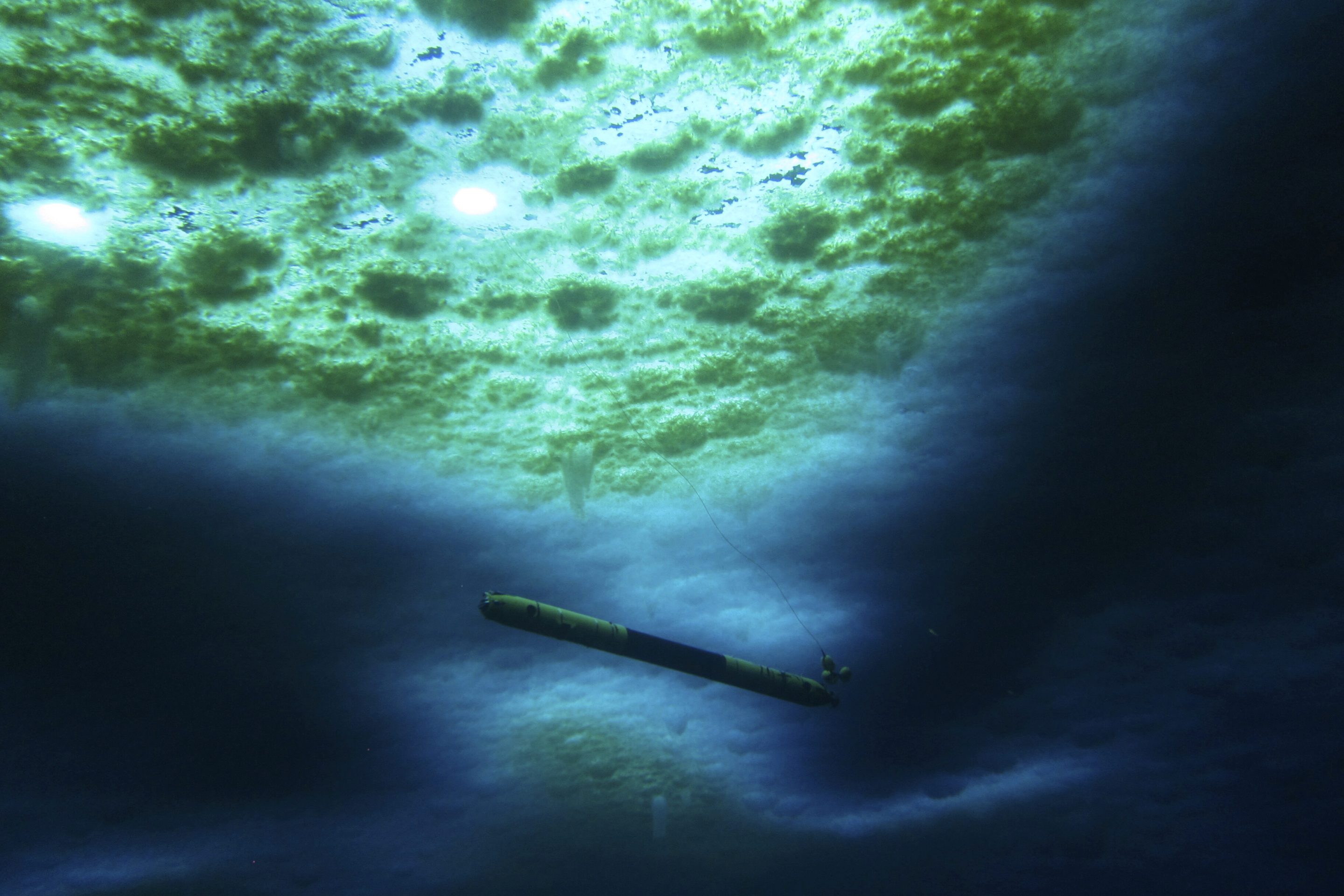 A robot nicknamed Icefin operates under the sea ice near McMurdo Station in Antarctica in 2020. The pencil-shaped robot is giving scientists their first look at the forces eating away at the Thwaites glacier.