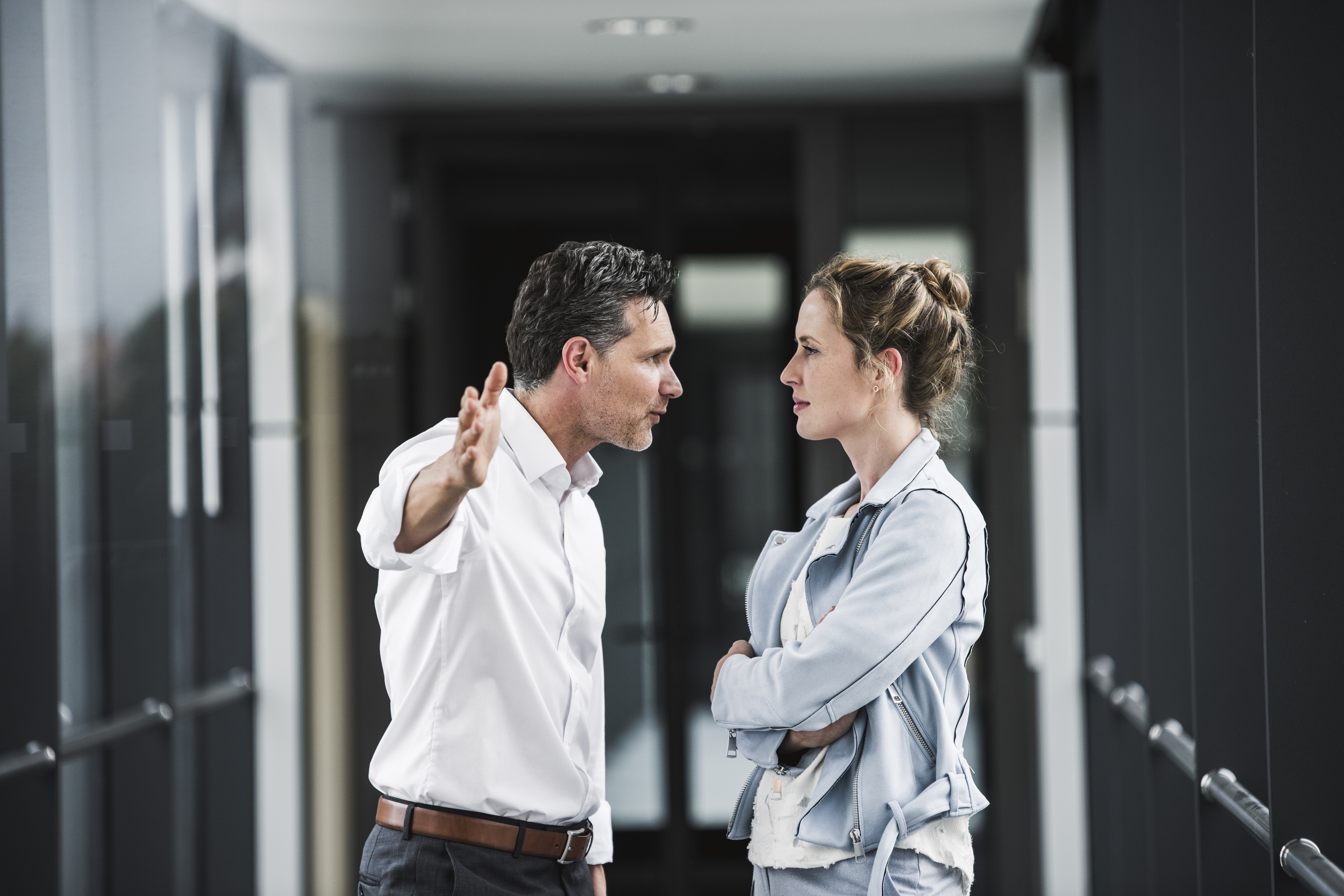 A man pictured shouting at a woman in an office setting