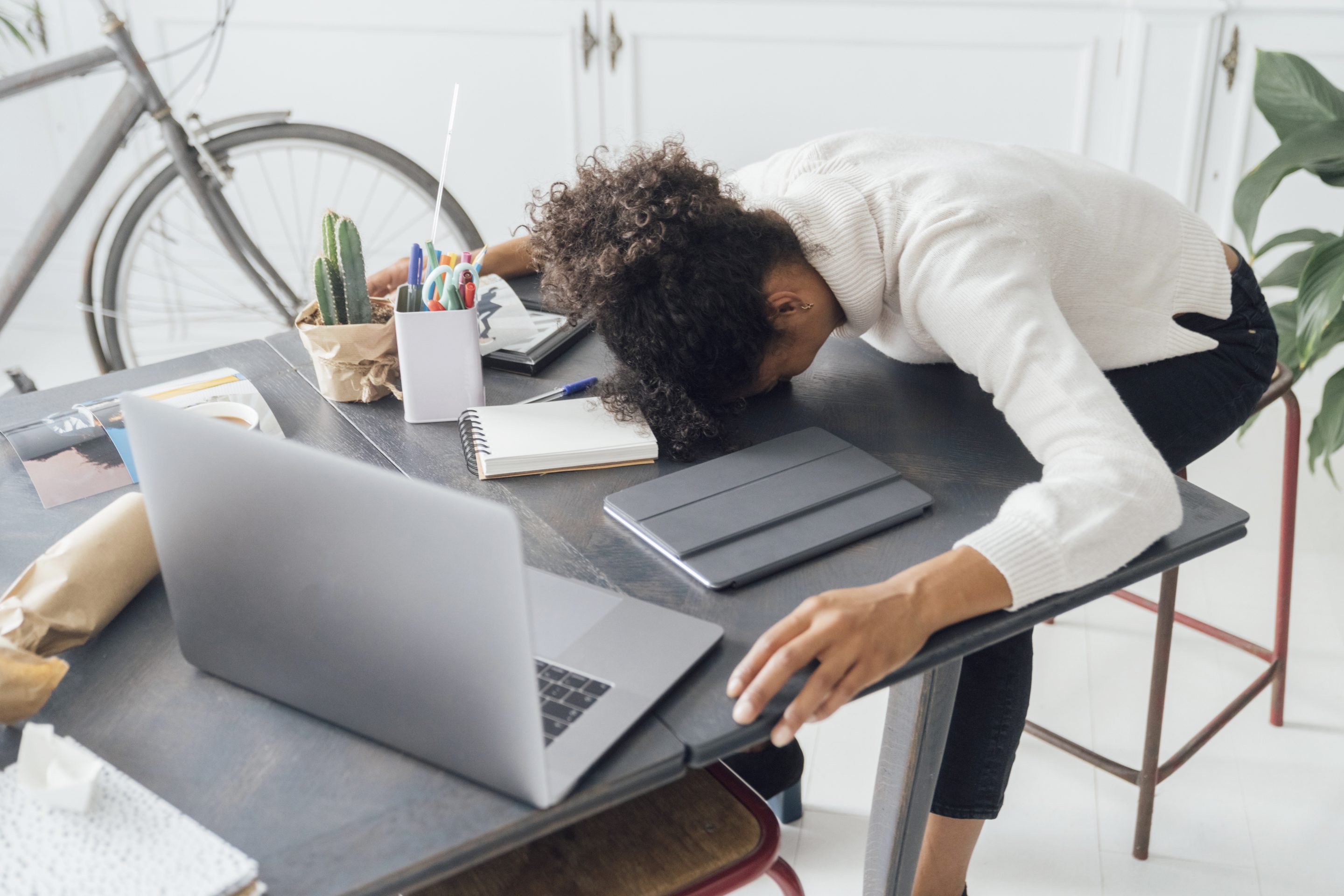 A burned out worker sleeping on her desk. 
