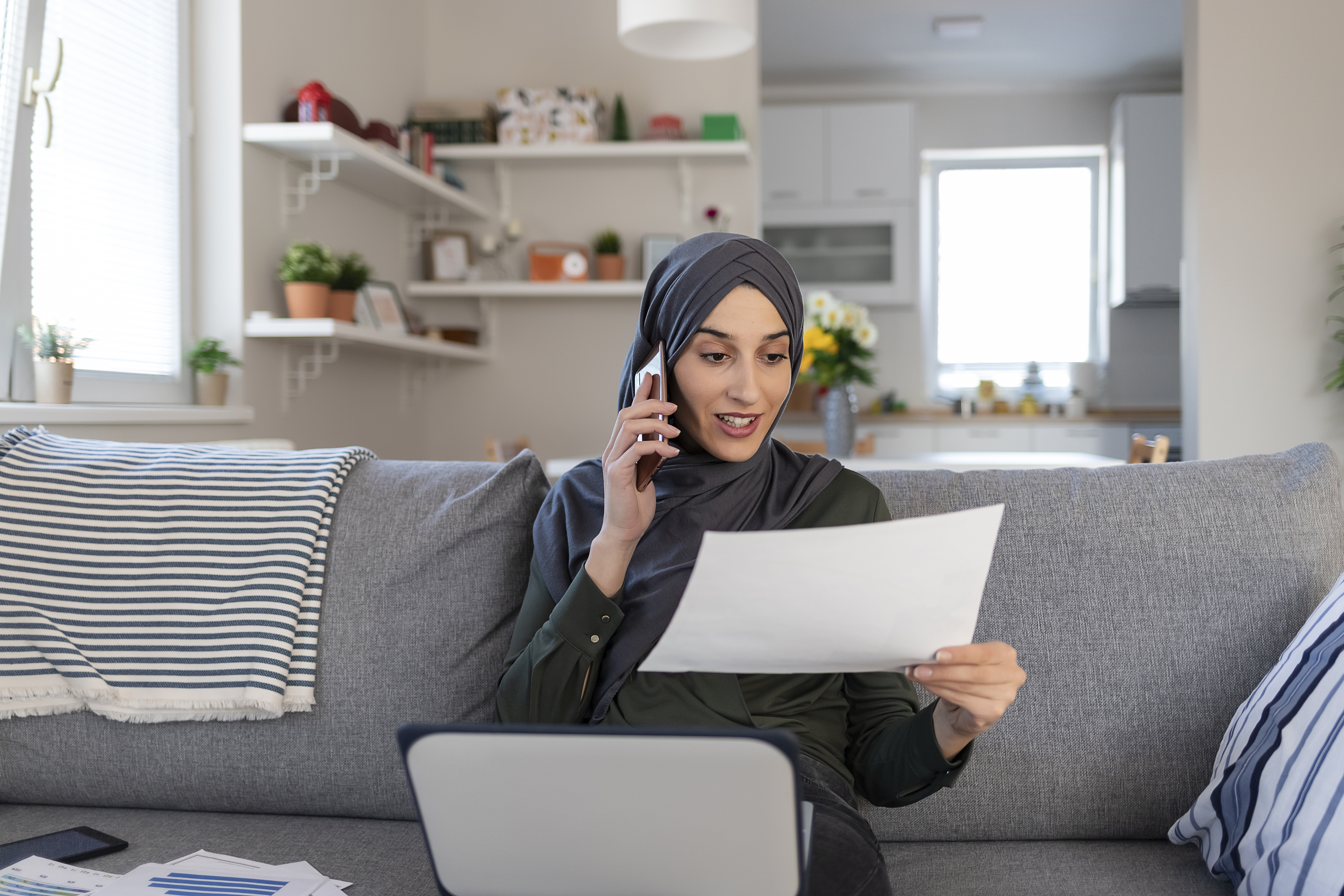 Woman in hijab talking on cellphone at home