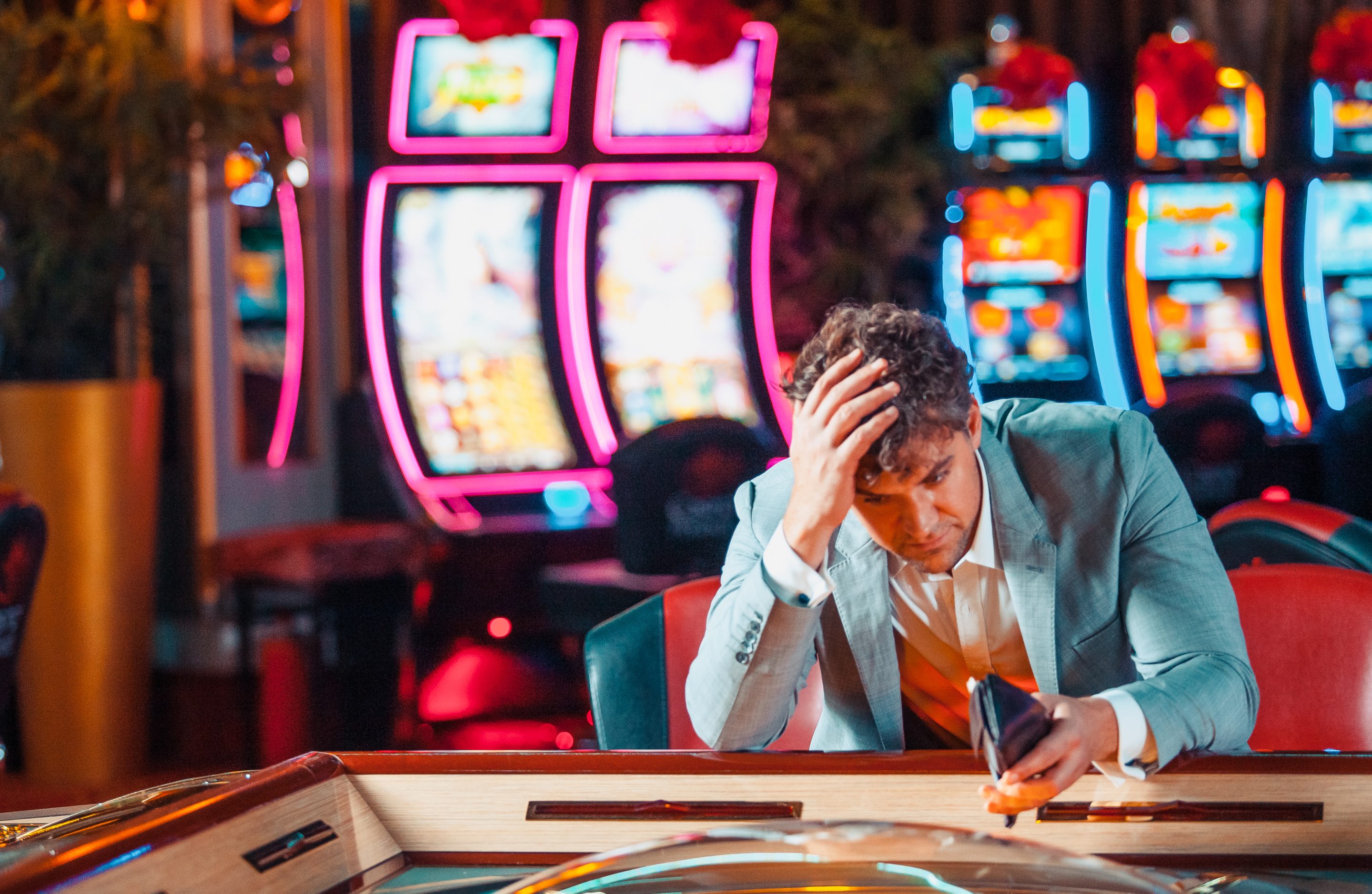 A man looking sad in a casino.