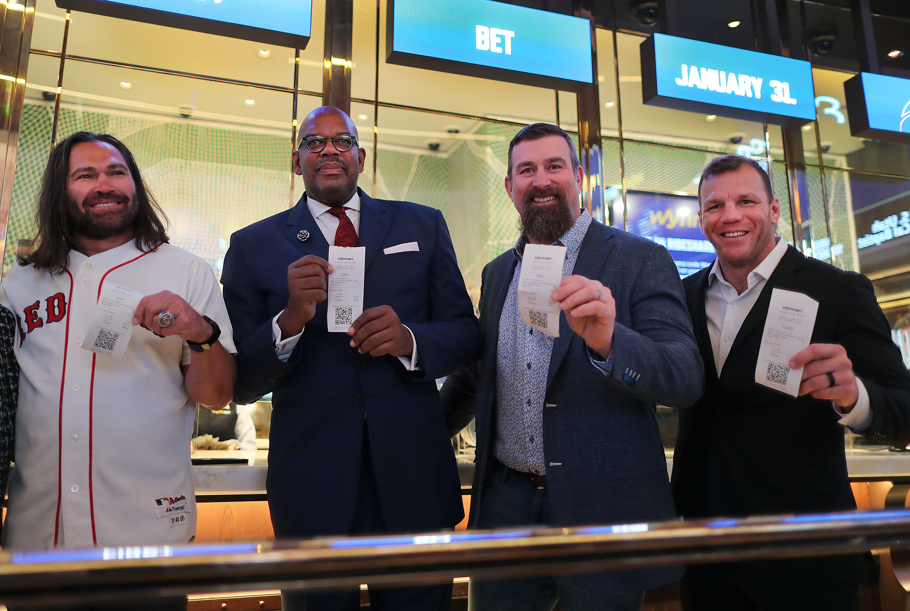 Four sports celebrities standing together.