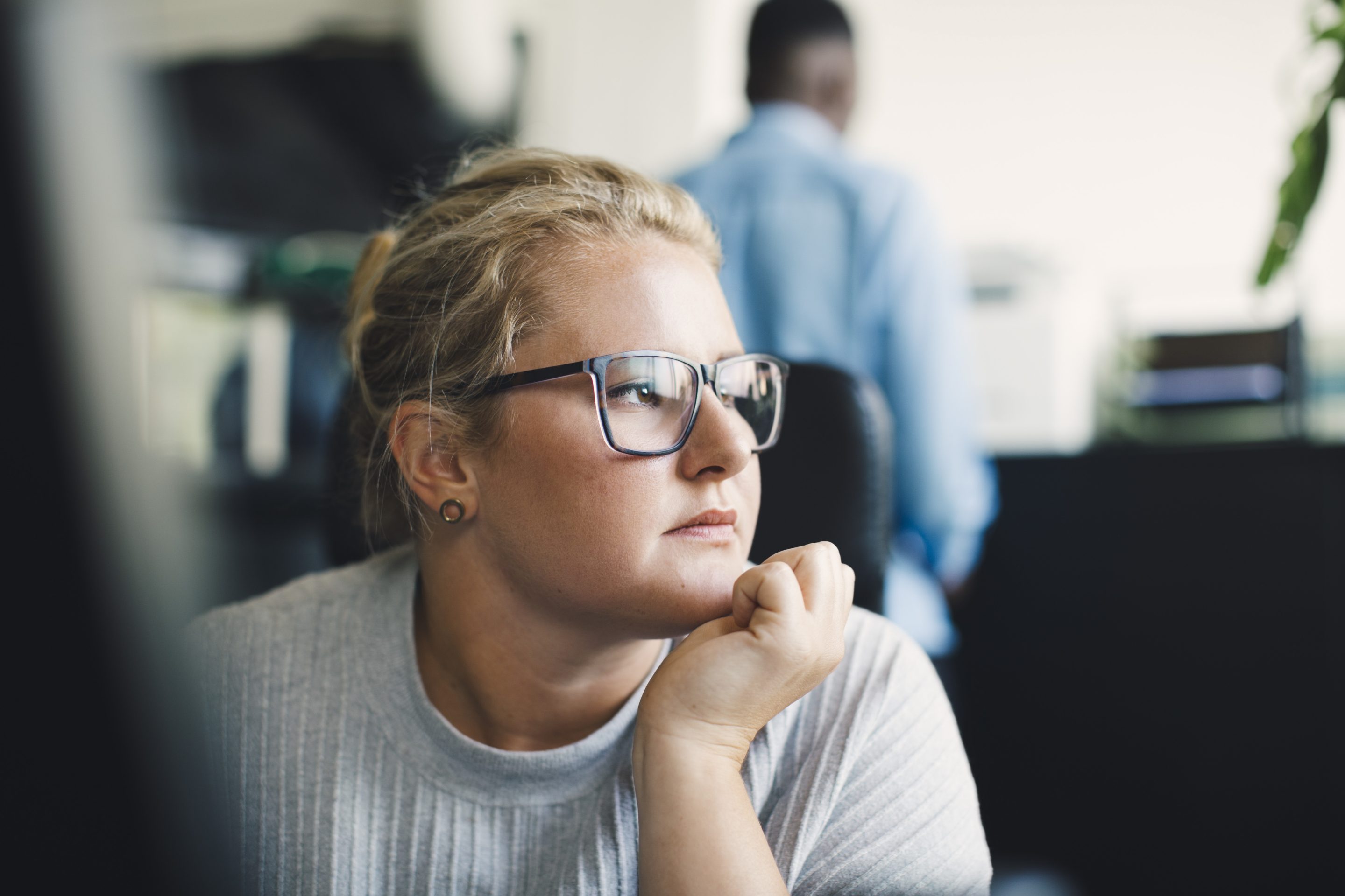 Woman in office looking away from her computer