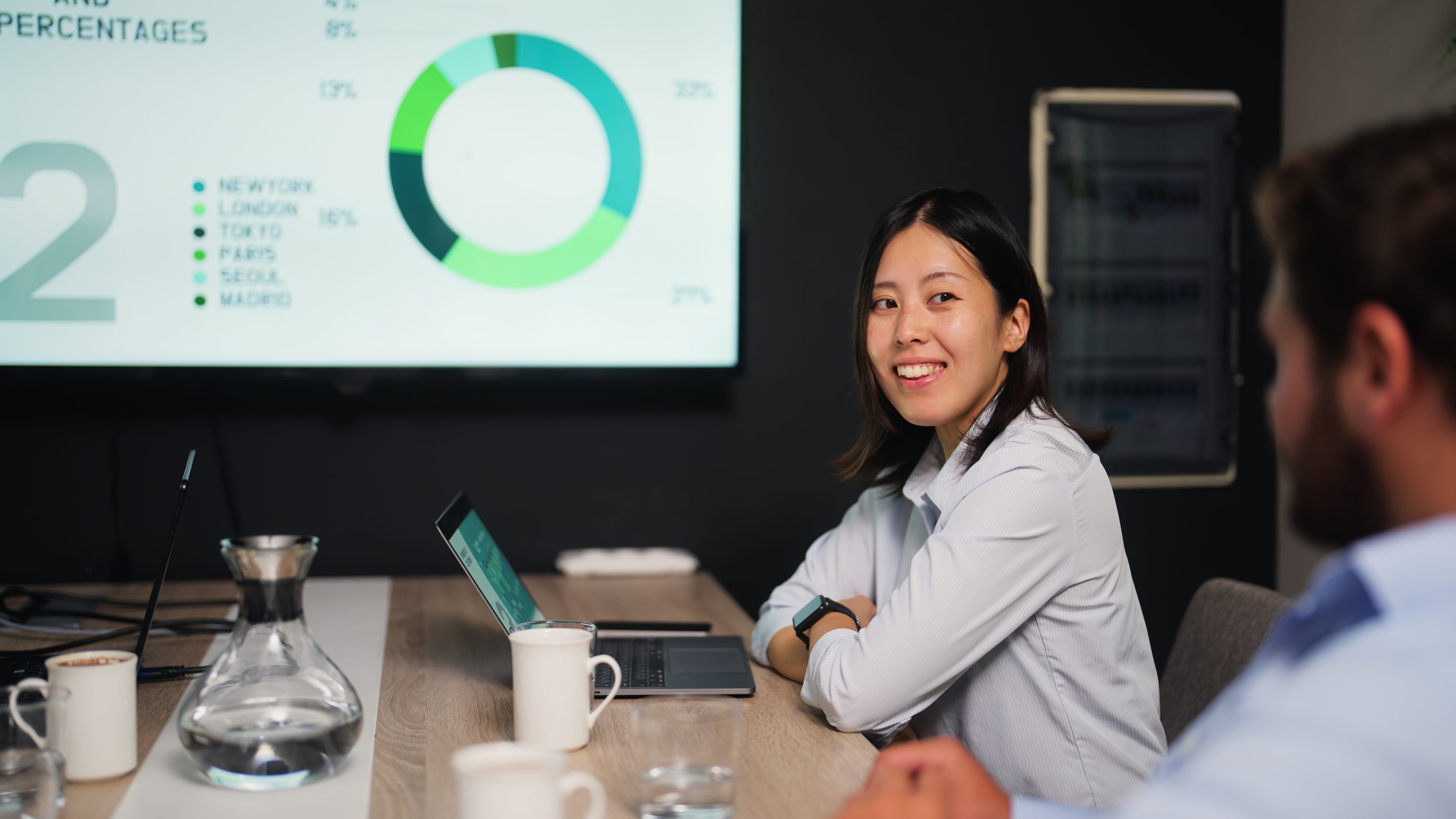 A young businesswoman is attending a business meeting in a meeting room in a modern office working space.