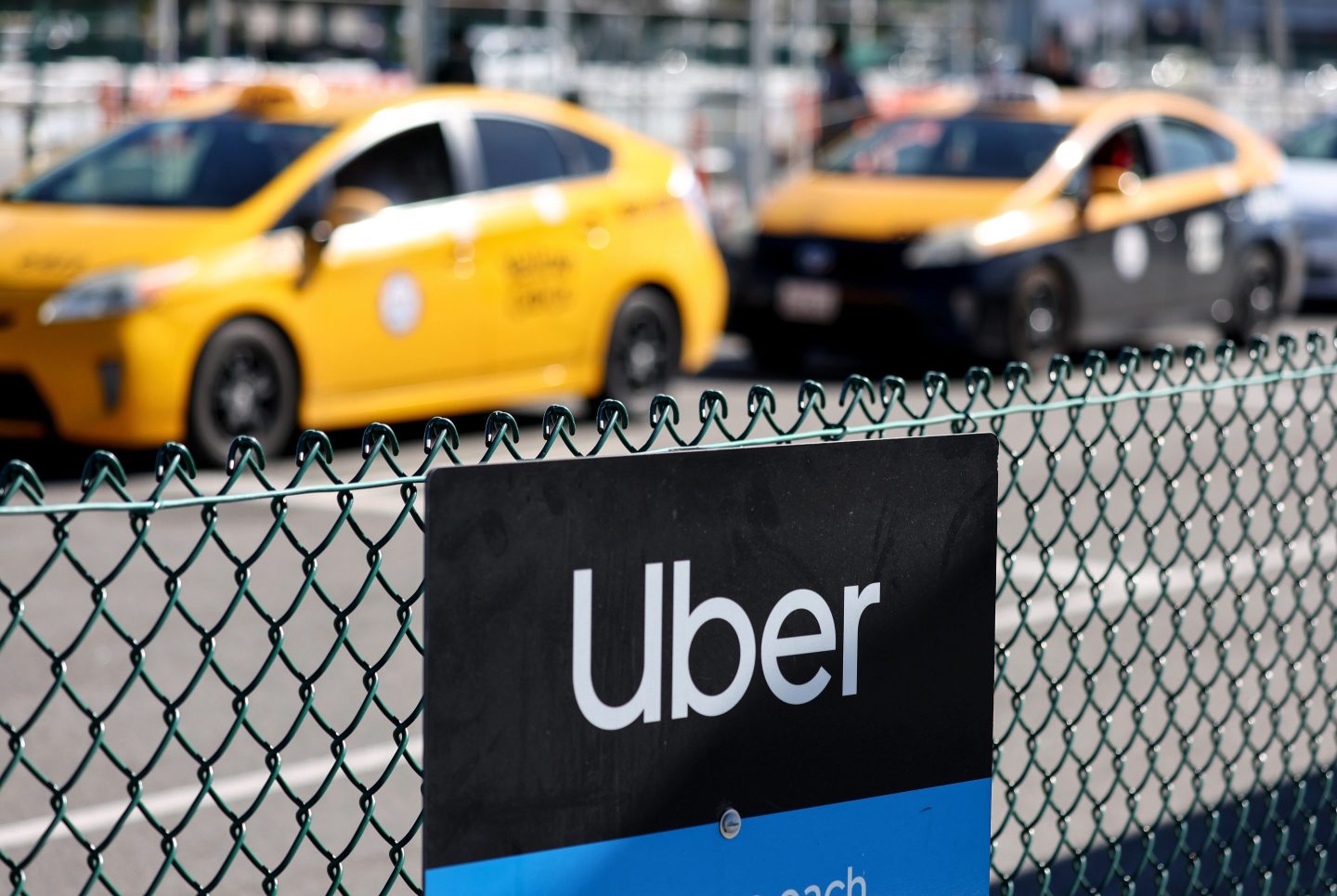 An Uber rideshare sign is posted nearby as taxis wait to pick up passengers at Los Angeles International Airport