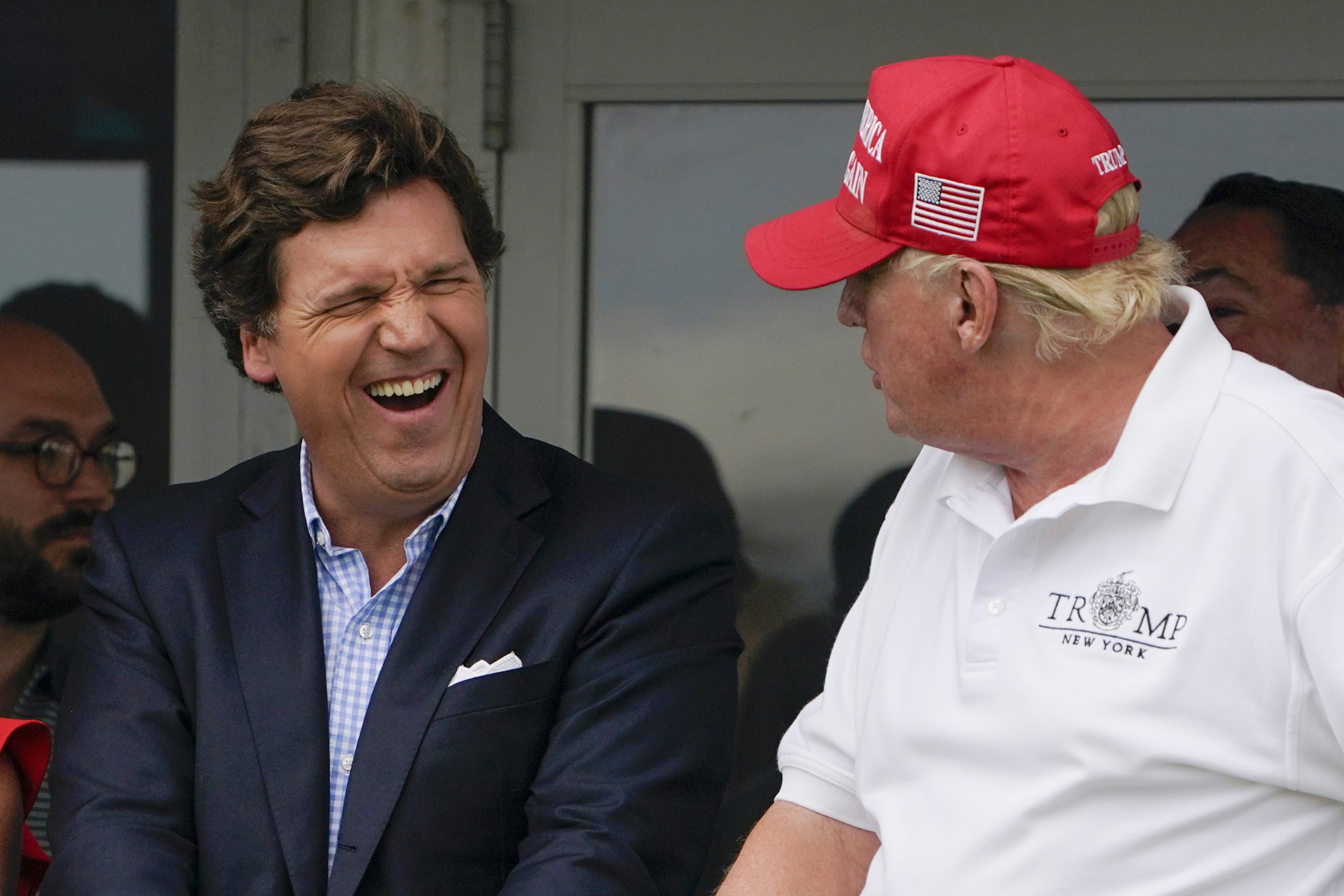 Tucker Carlson and former President Donald Trump react during the final round of the Bedminster Invitational LIV Golf tournament in Bedminster, N.J., July 31, 2022.